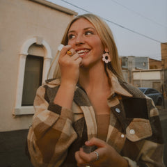 Plaid shirt jacket in brown and tan with button closure, worn by smiling woman outdoors