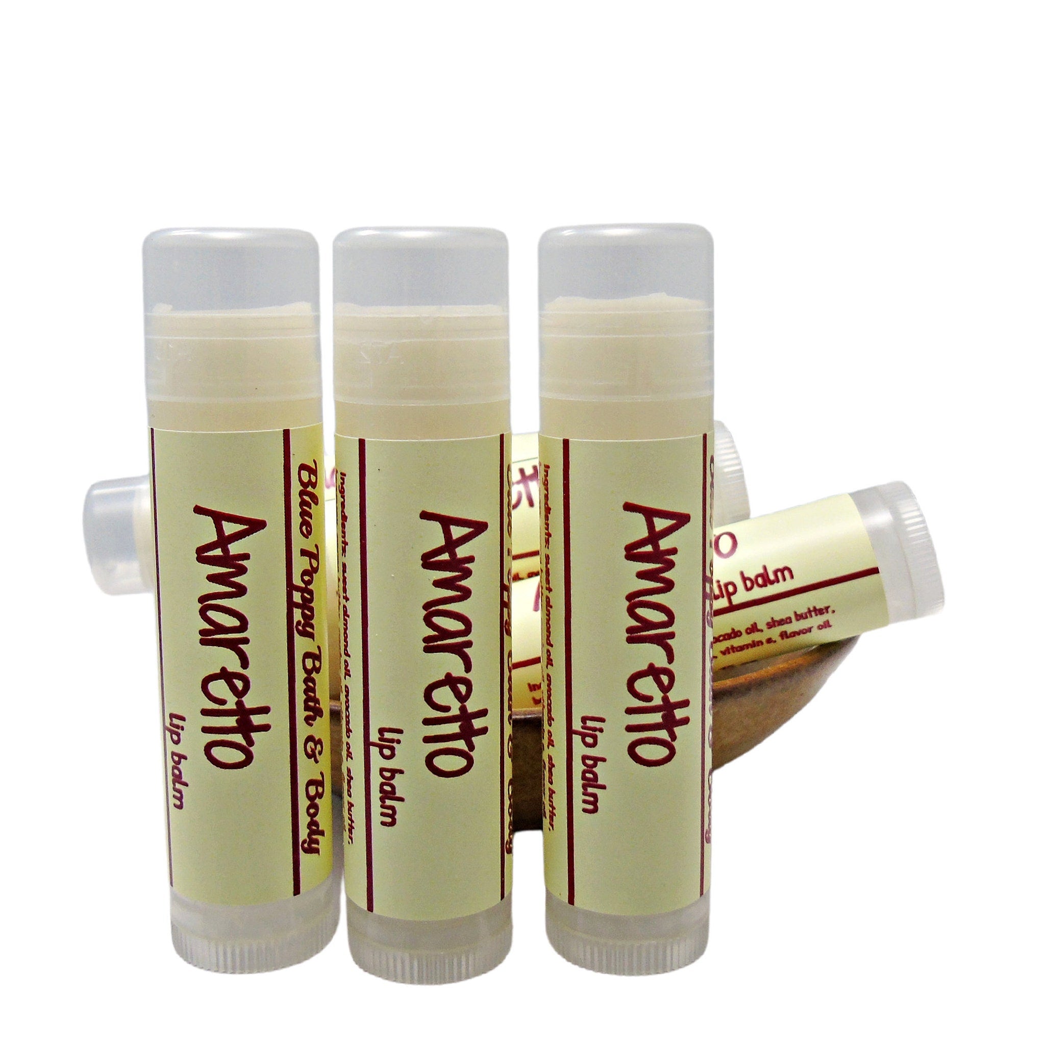 Lip balm tubes with white caps, light yellow labels, and Amaretto text