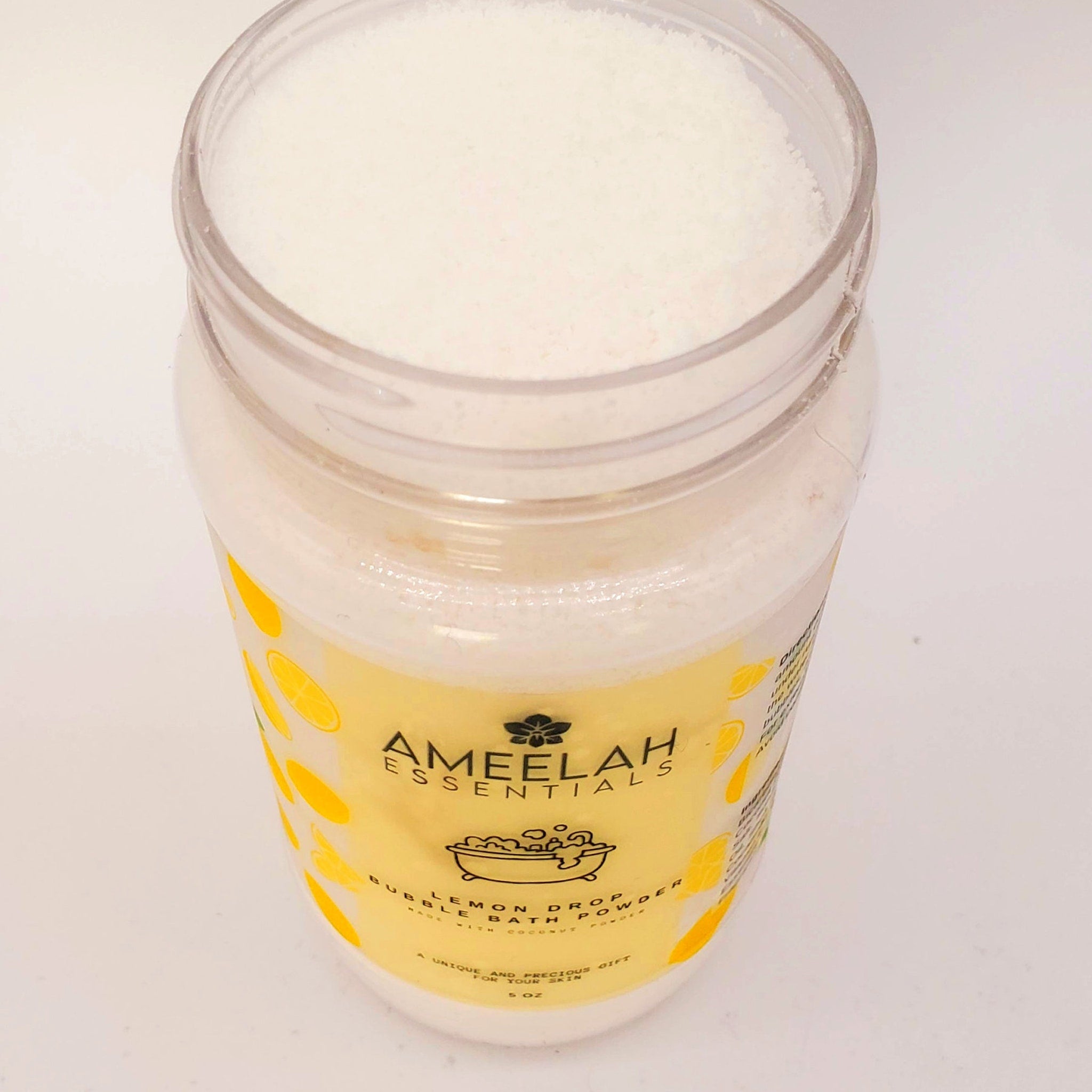 Bubble bath powder in clear jar with white powder and yellow label, Ameelah Essentials brand