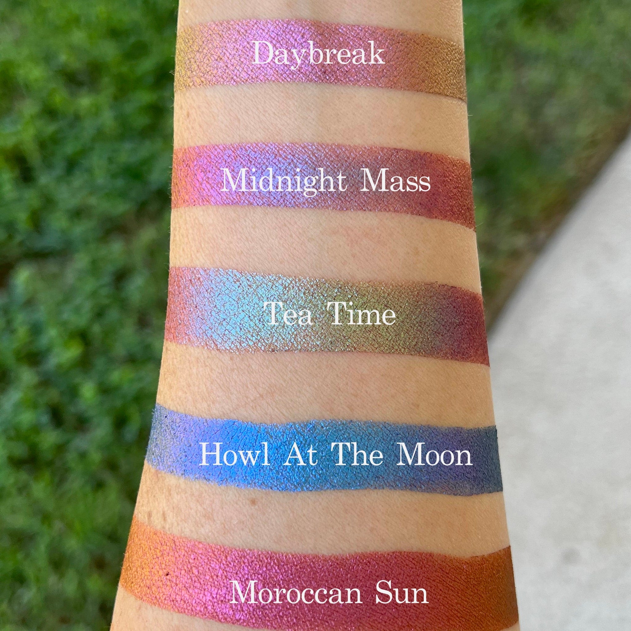 Side view of holographic Tea Time eyeshadow pan showing color-shifting multi-chrome finish in compact