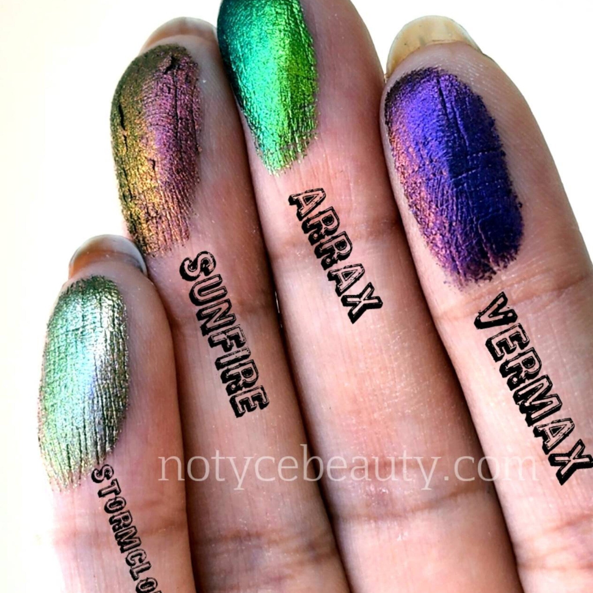 Eyeshadow swatches, iridescent green and purple hues on fingers, with brand text visible