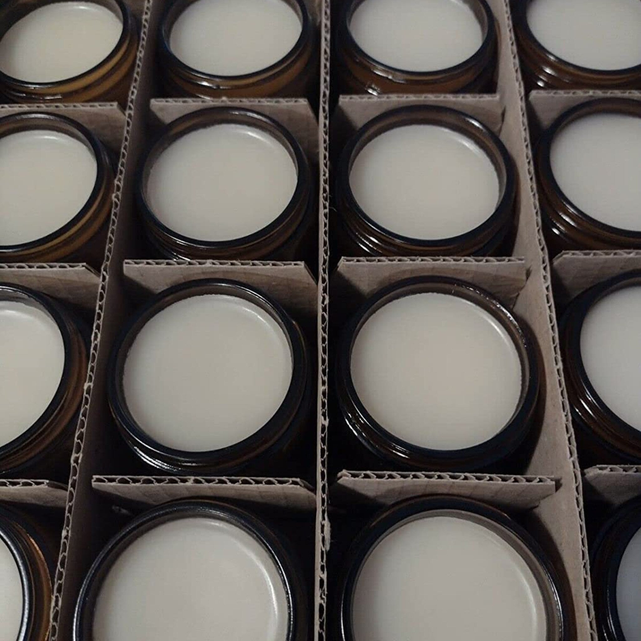 Cream jars with brown glass, white cream, and cardboard packaging for shipping