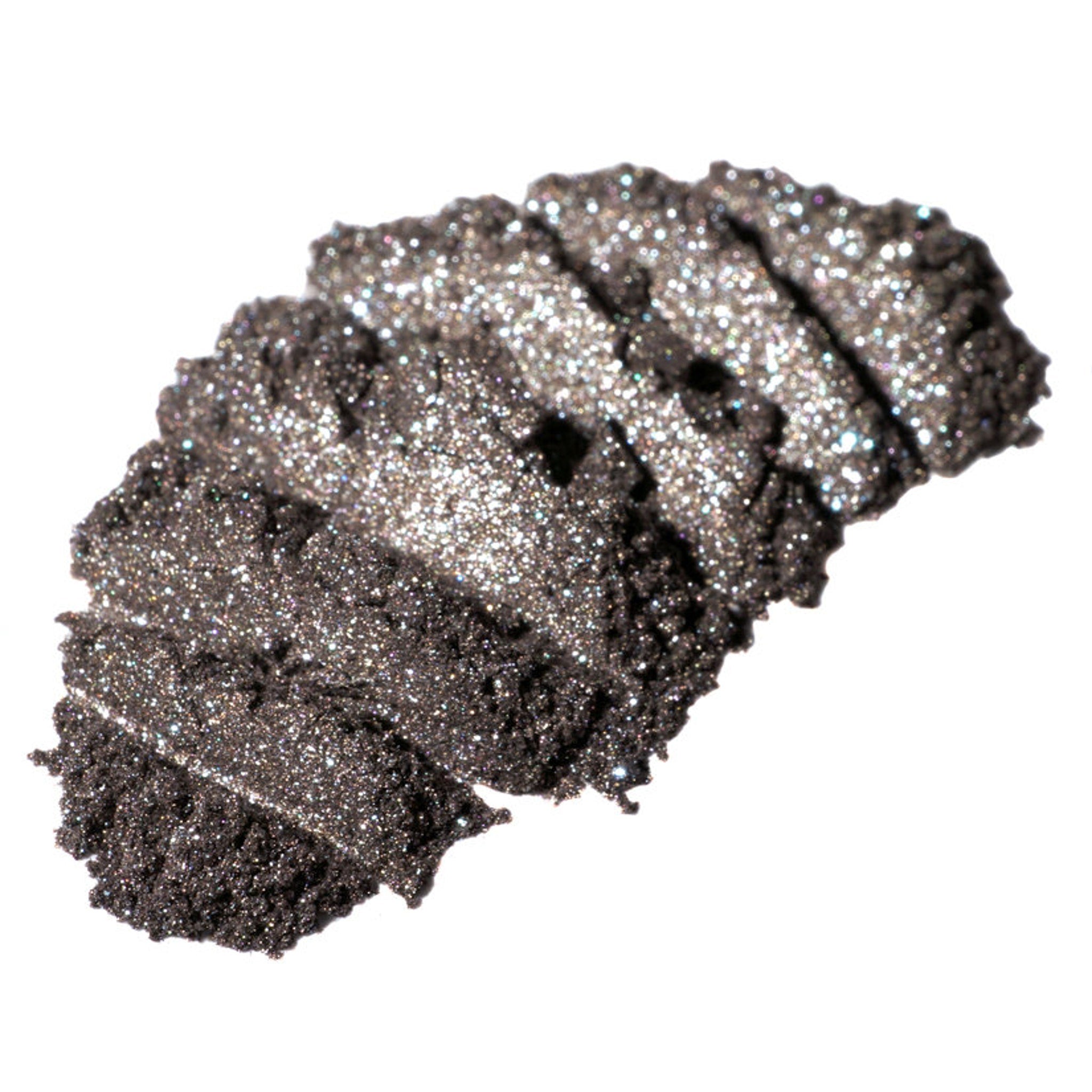 Hand applying cool bronze loose pigment eyeshadow with metallic brown base and silver-gold glitter particles