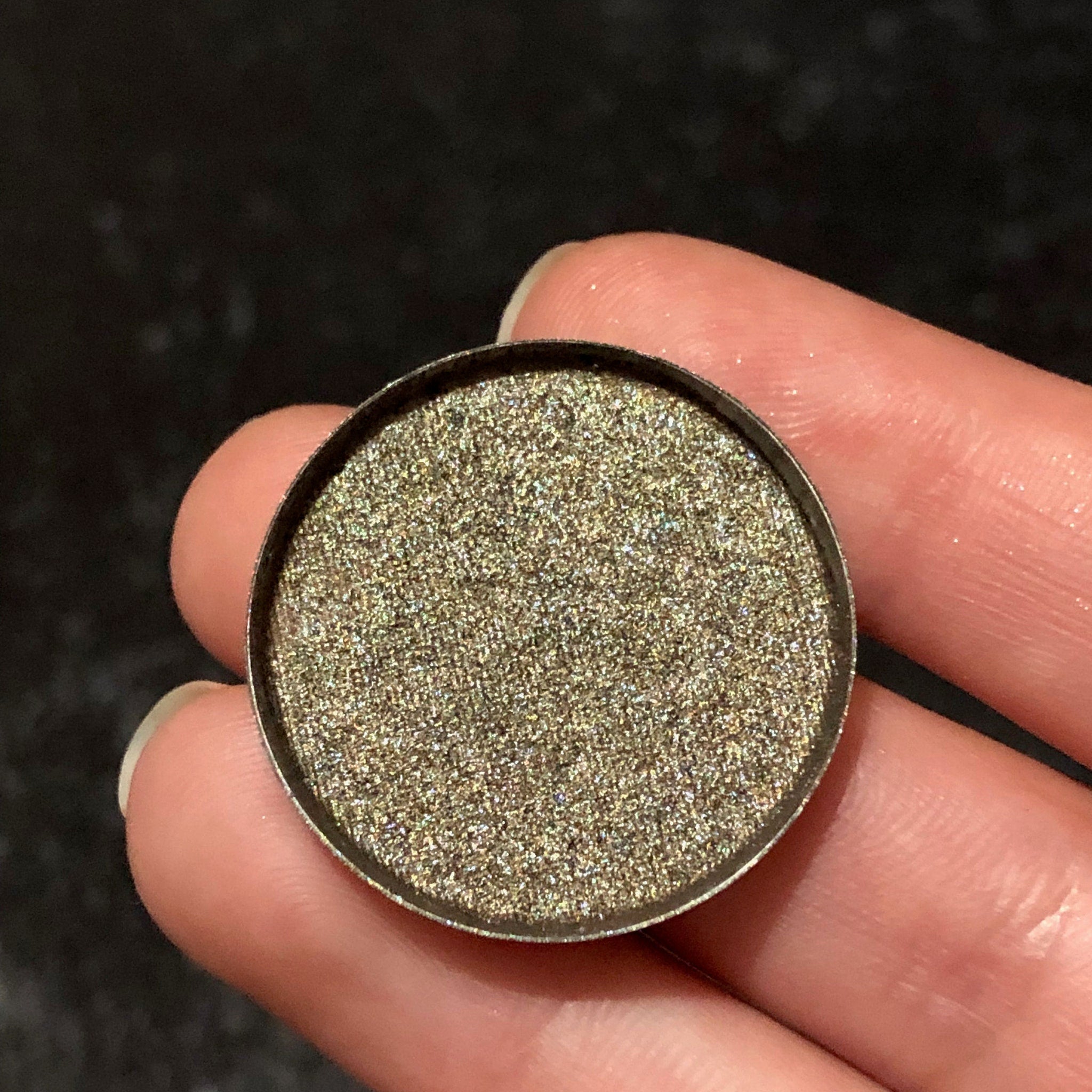 Single Celebration eyeshadow in a round compact with shimmering champagne gold powder and black case