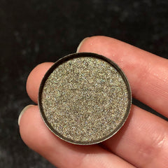 Single Celebration eyeshadow in a round compact with shimmering champagne gold powder and black case