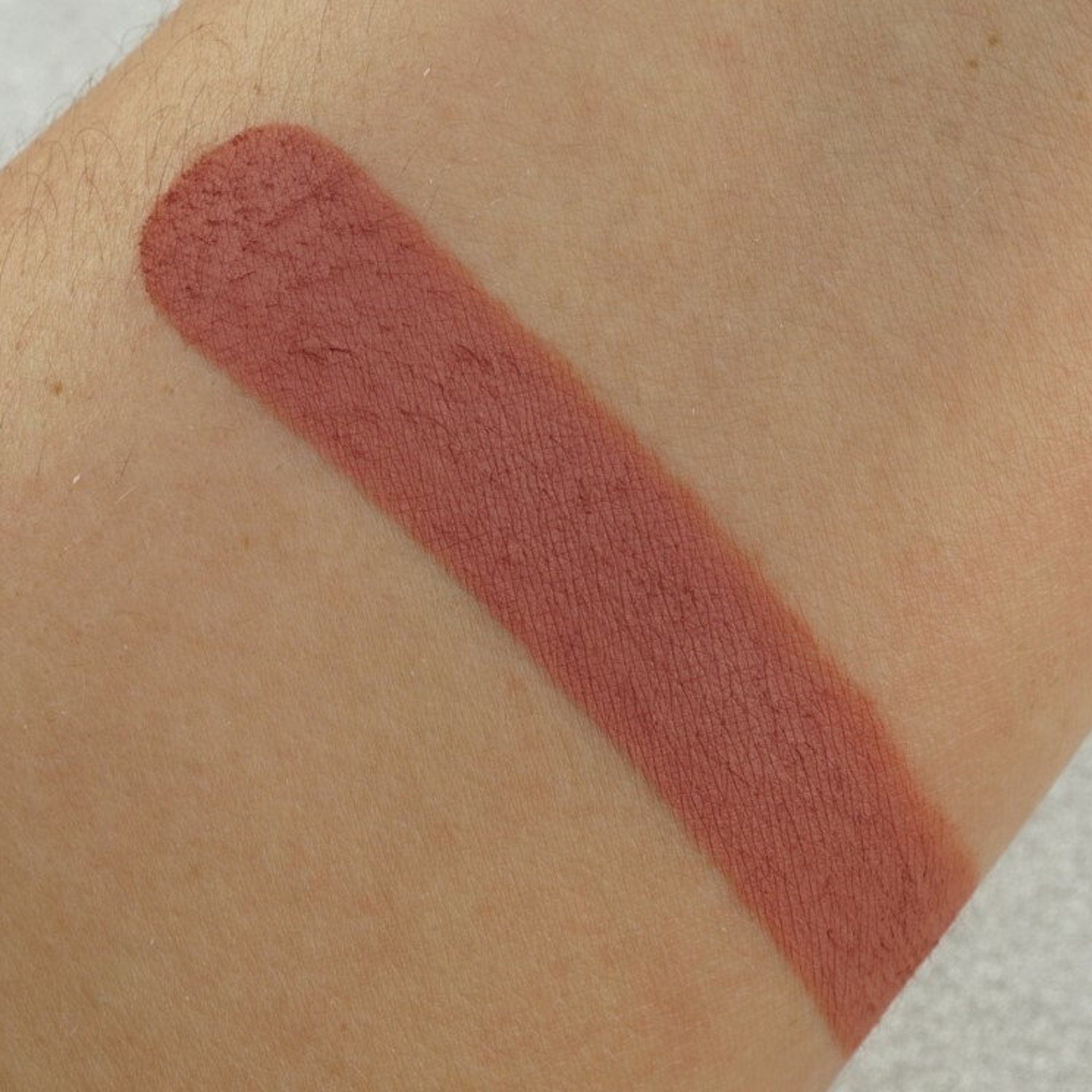 Lipstick swatch, matte finish, dusty rose color on skin, for color comparison
