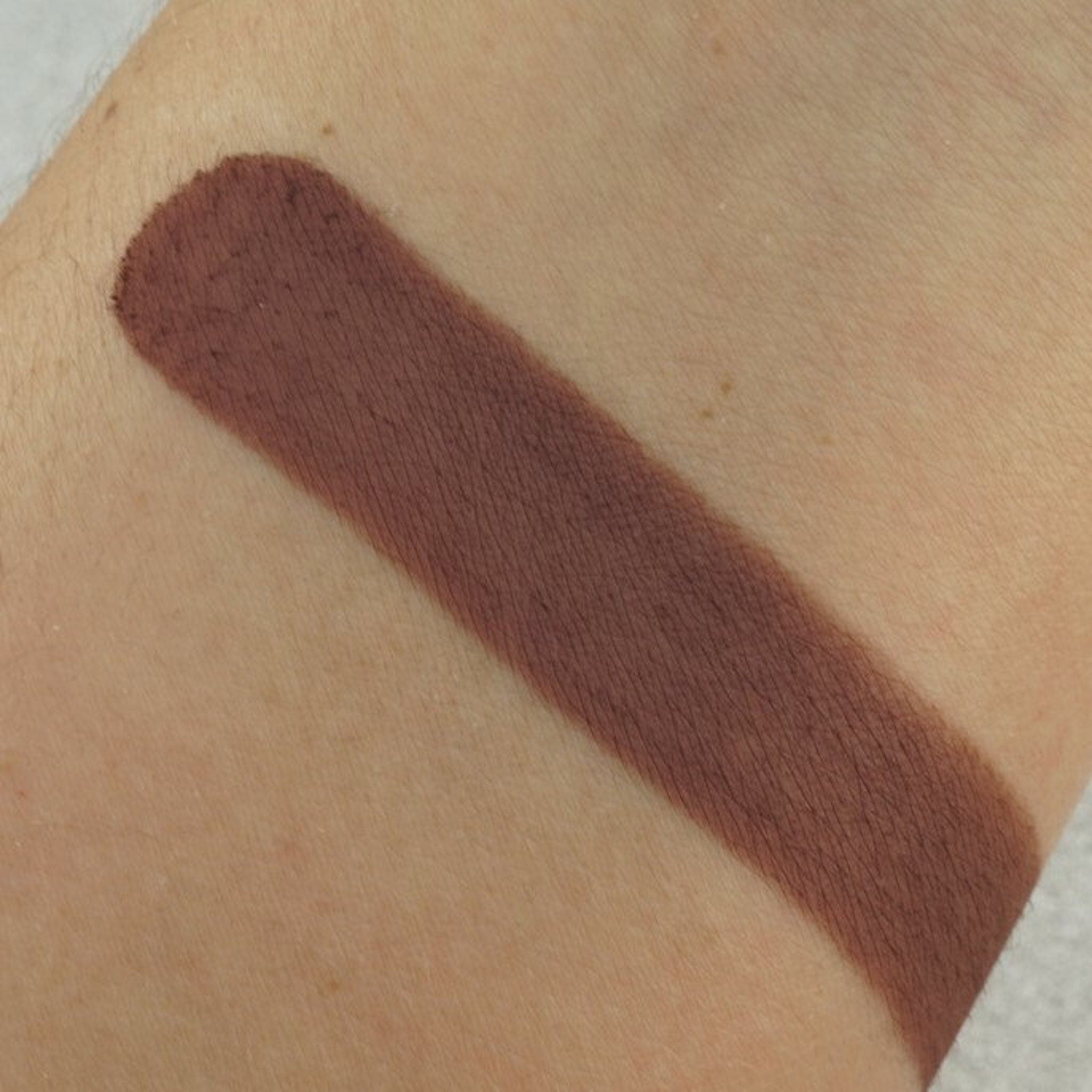Close-up of matte pressed eyeshadow pan showing smooth pigment texture in a neutral shade
