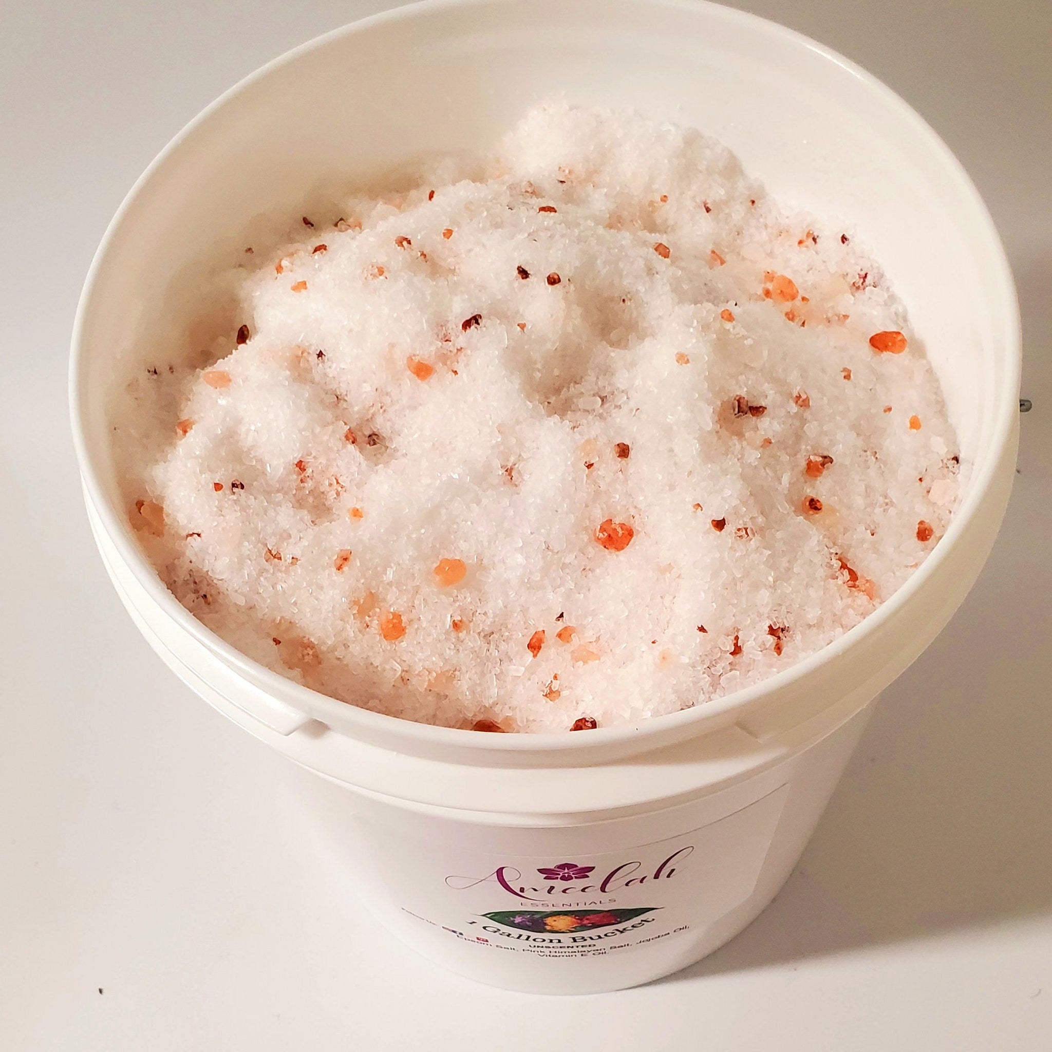 Bath salts with white and pink crystals in a white bucket, Ameelah Essentials label visible