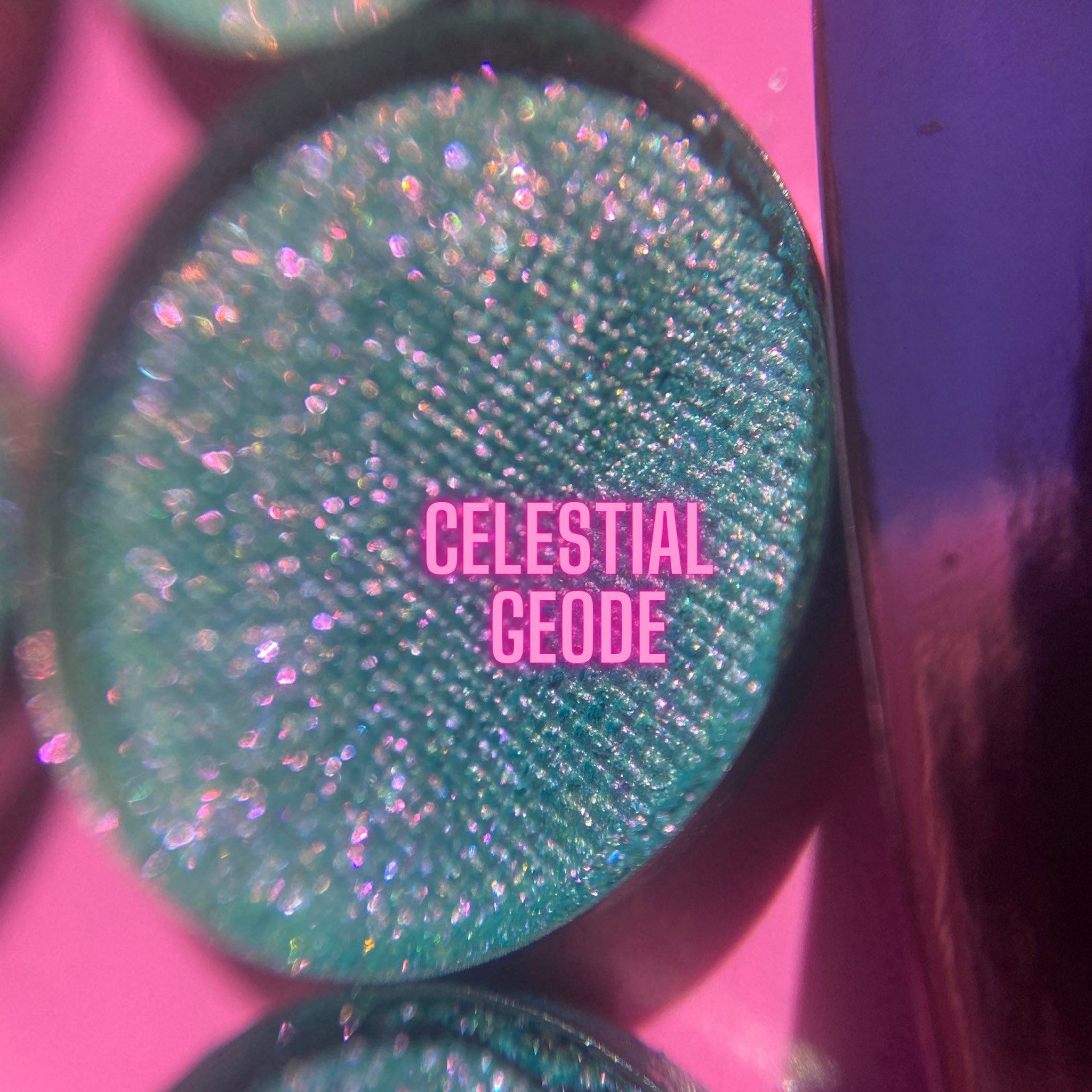 Eyeshadow with teal glitter and "CELESTIAL GEODE" text on pink and purple background
