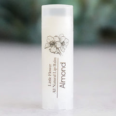 Lip balm tube with white color, floral illustration, and "Almond" text