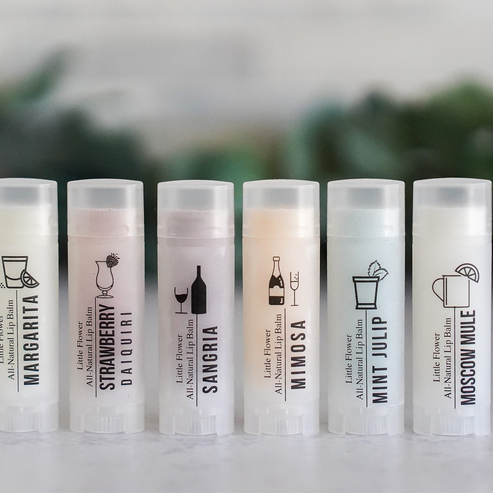 Lip balms, white plastic tubes with cocktail illustrations and text, Little Flower brand