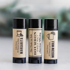 Lip balms with black tubes and tan labels, Little Flower Soap Co brand, Margarita, Bourbon, and Moscow Mule flavors