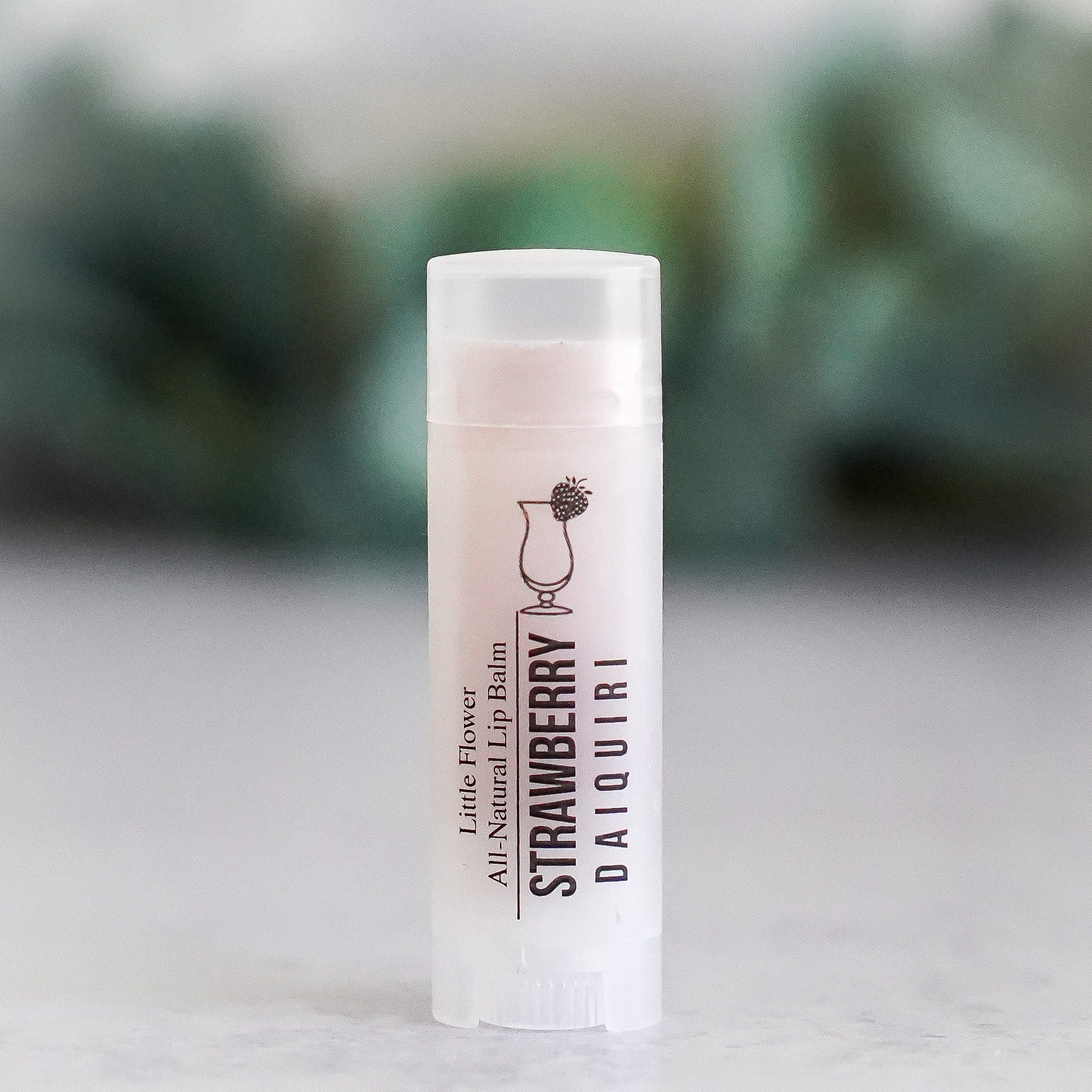 Lip balm tube with white plastic, clear cap, and Strawberry Daiquiri text label.