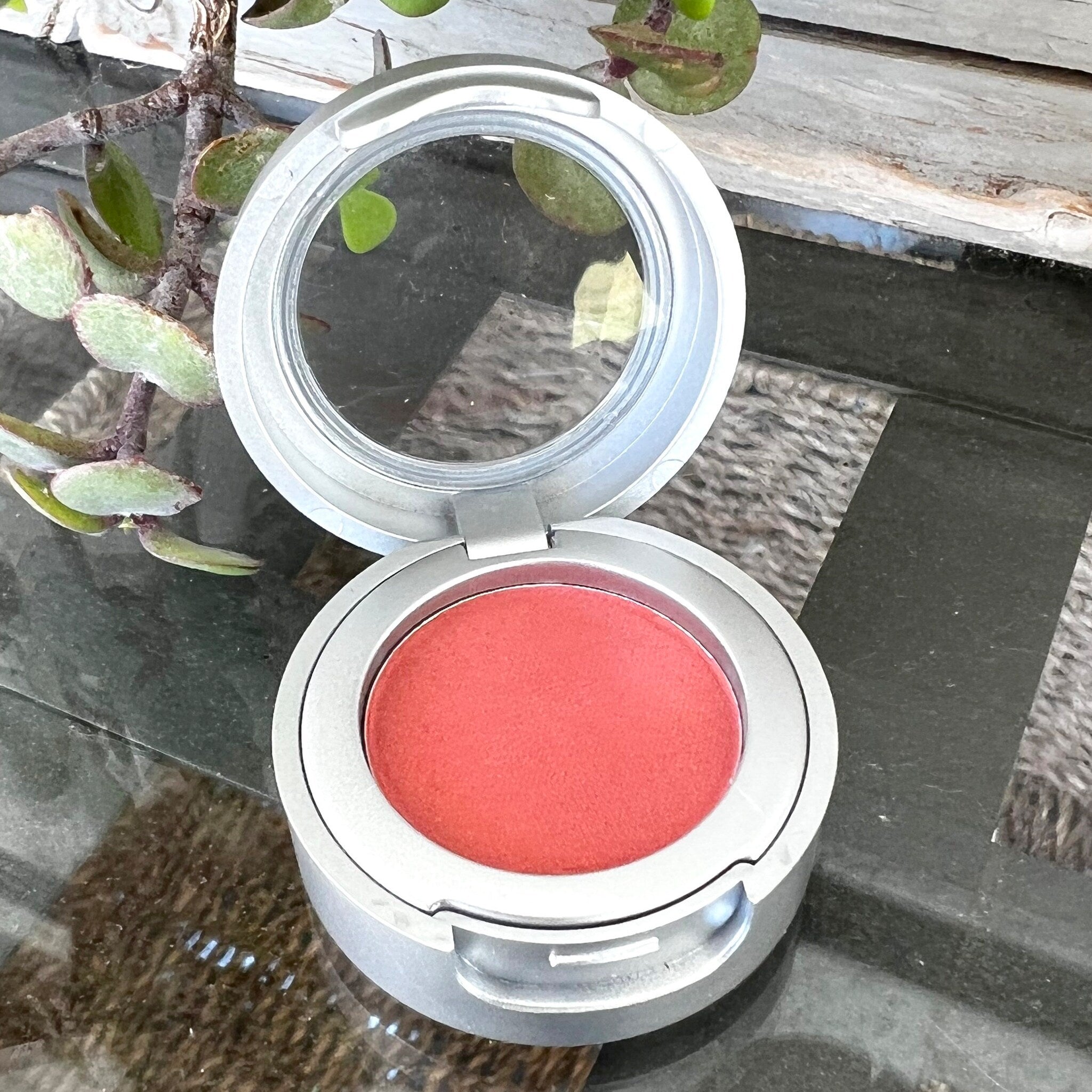 Close-up of pressed matte eyeshadow pan showing smooth pigment texture in a neutral earthy tone