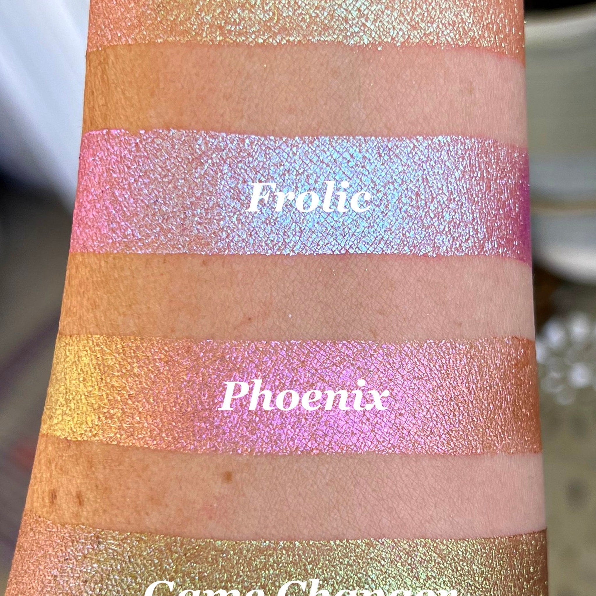 Side view of holographic multi-chrome eyeshadow compact showing shifting iridescent hues on angled surface