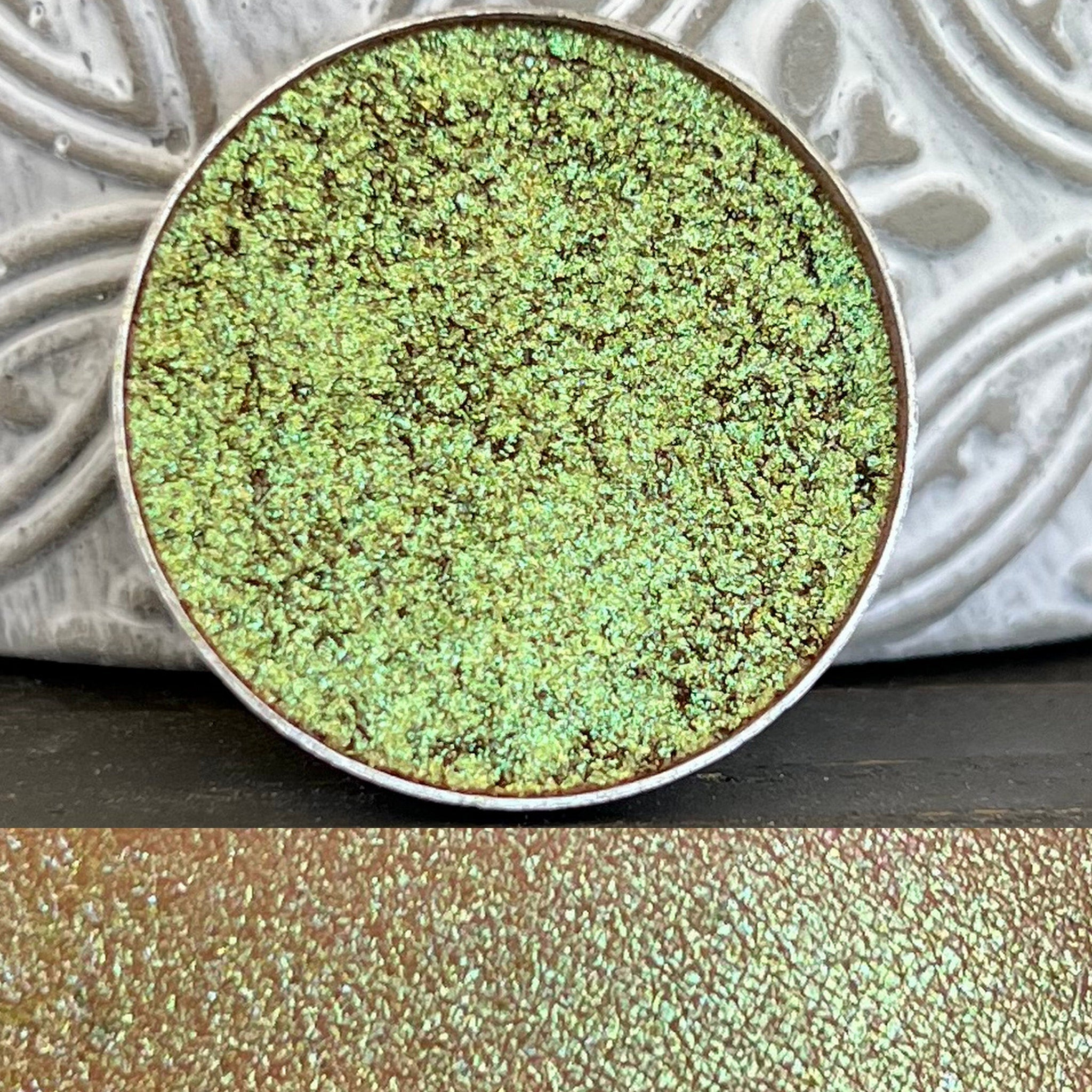 Pressed holographic eyeshadow compact with multi-chrome shifting colors in iridescent finish