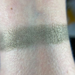 Close-up of Betelgeuse eye shadow pan showing vibrant orange-red pigment with smooth satin finish