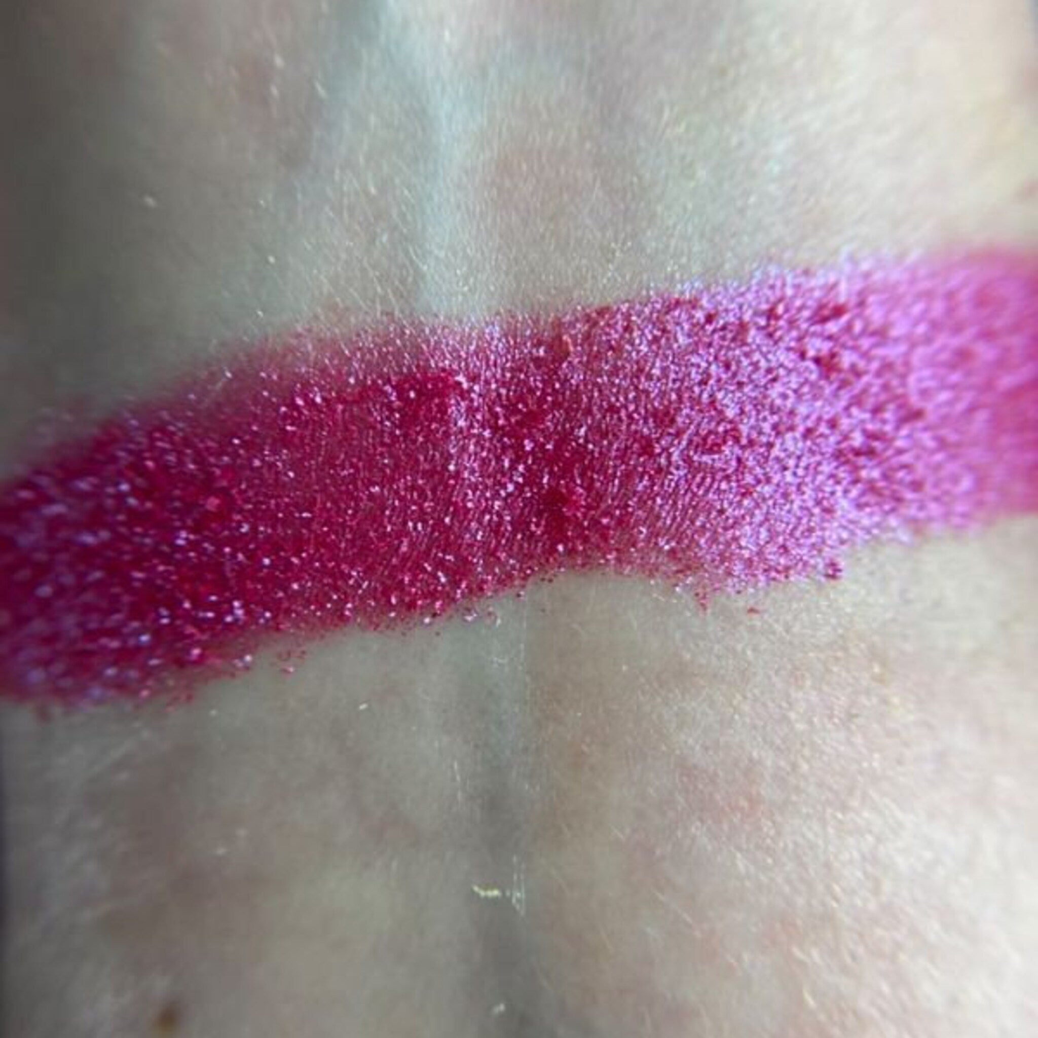 Close-up of fingertips applying shimmering taupe Tickle Eye Shadow to eyelid with soft blending motion