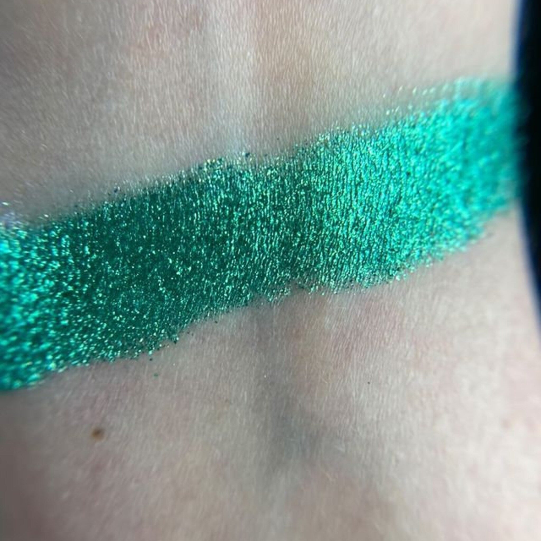 Side view of zodiac-inspired eye shadow palette showcasing twelve vibrant shades in matte and shimmer finishes with celestial designs.