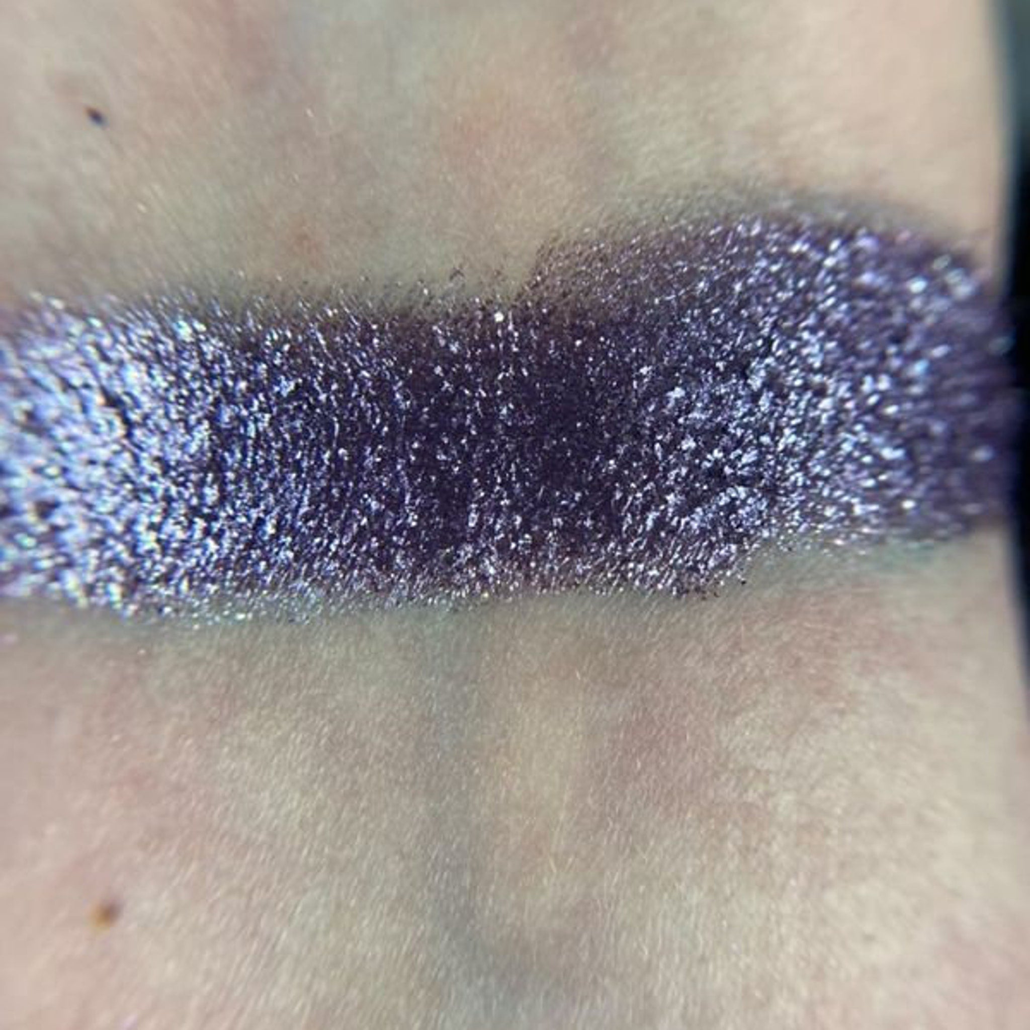 Side view of Constellation Eye Shadow Palette showcasing twelve shimmering shades in cosmic hues with sleek black case