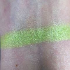 Hand applying shimmery soup-inspired eyeshadow with a blending brush on eyelid