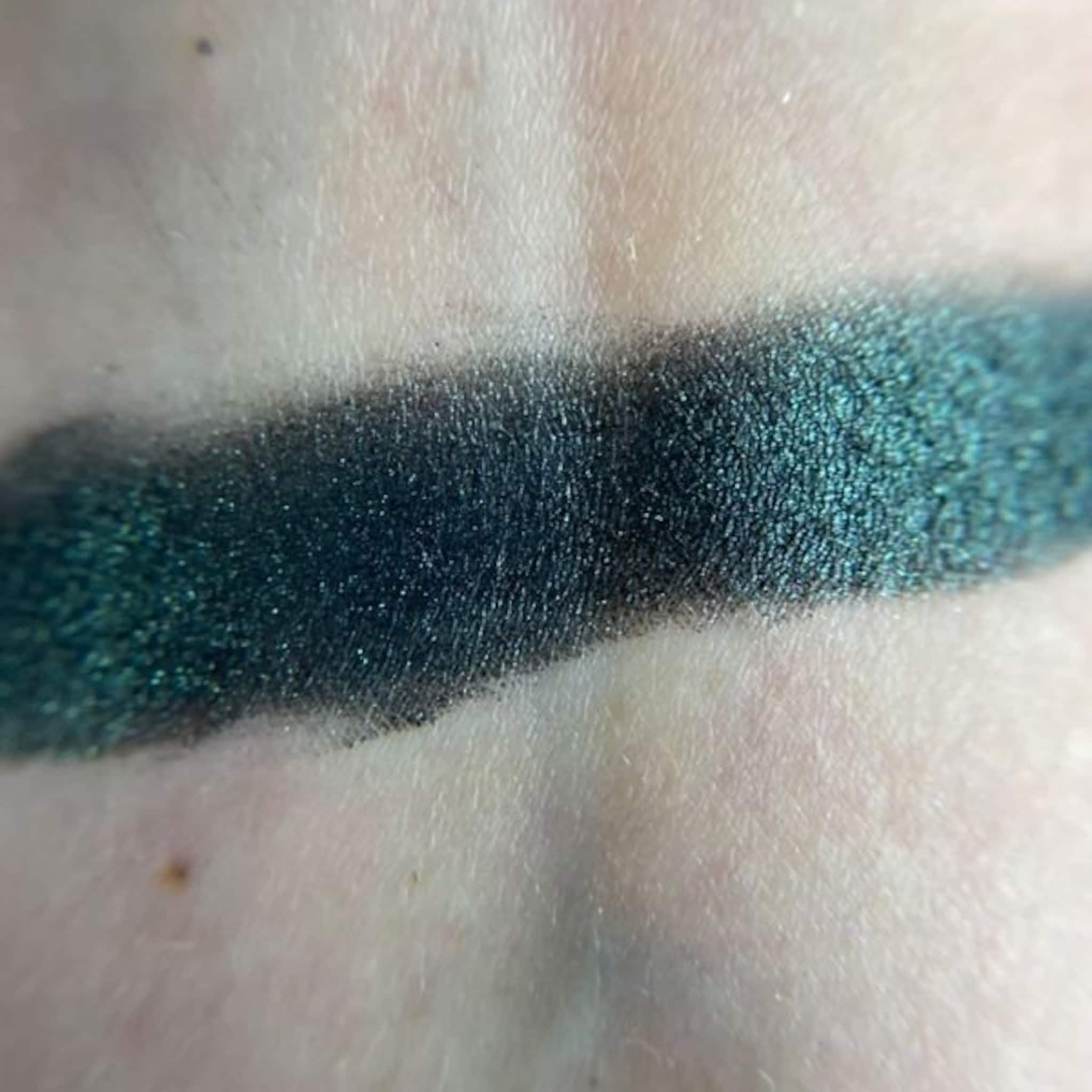 Close-up of three matte eye shadow pans in warm brown, peach, and cream tones with smooth texture