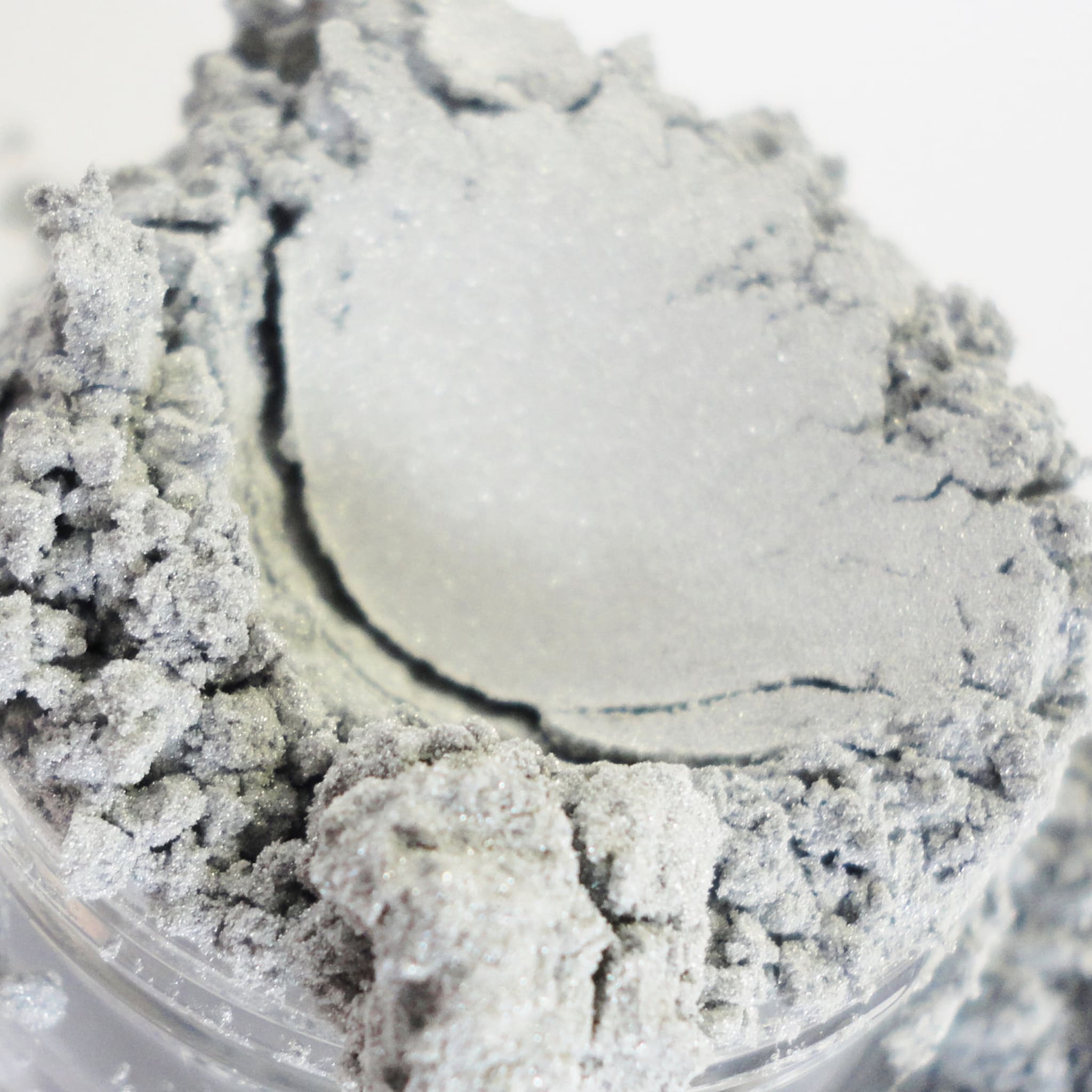Silver powder with granular texture and light reflection in a container