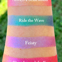 Side angle view of Ring Around the Rosy holographic eyeshadow compact showing multi-chrome pink shift in pressed pan
