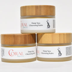 Cleansing balm jars with bamboo lids, white labels, and Coral Skin Co text