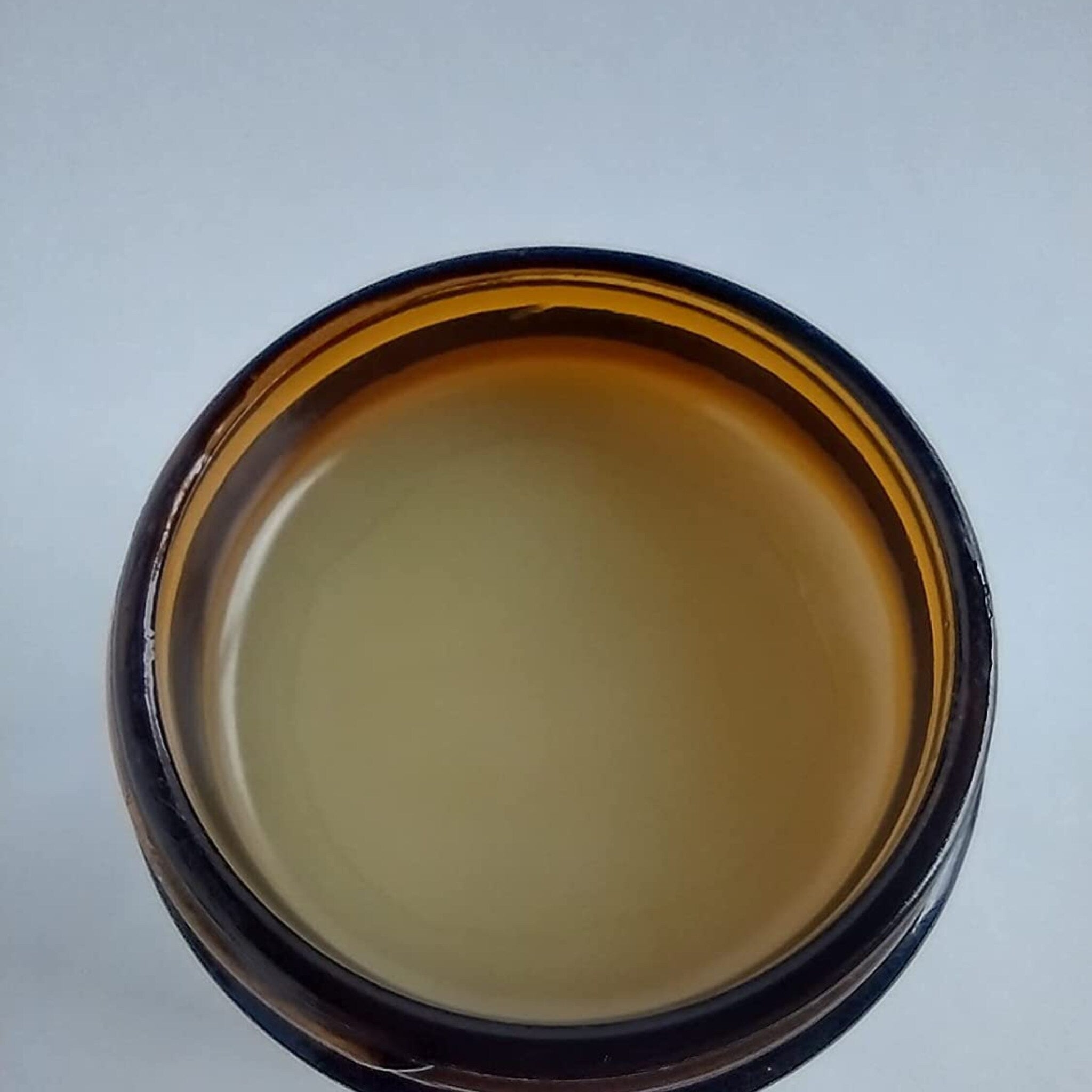 Jar of amber glass with light yellow contents, top-down view