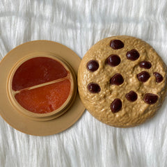 Close-up of vintage 70s Avon lip gloss compact showing golden floral detailing and mirrored interior
