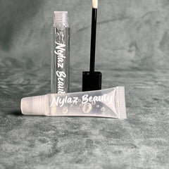 Lip gloss tubes, clear liquid, white text, black applicator, Nyiaz Beauty brand