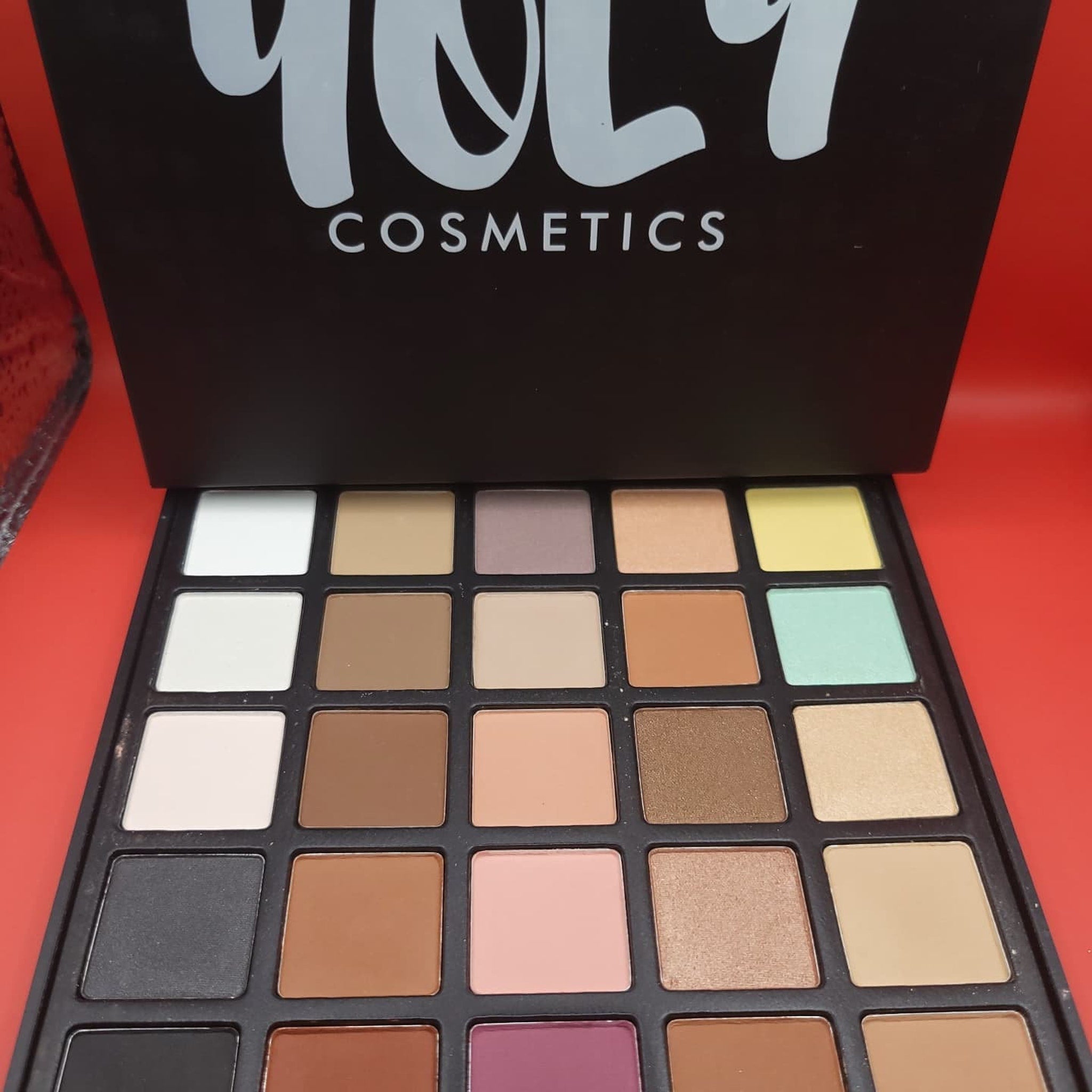 Side view of 25-color eyeshadow palette showing gradient of matte and shimmer shades in rectangular pans