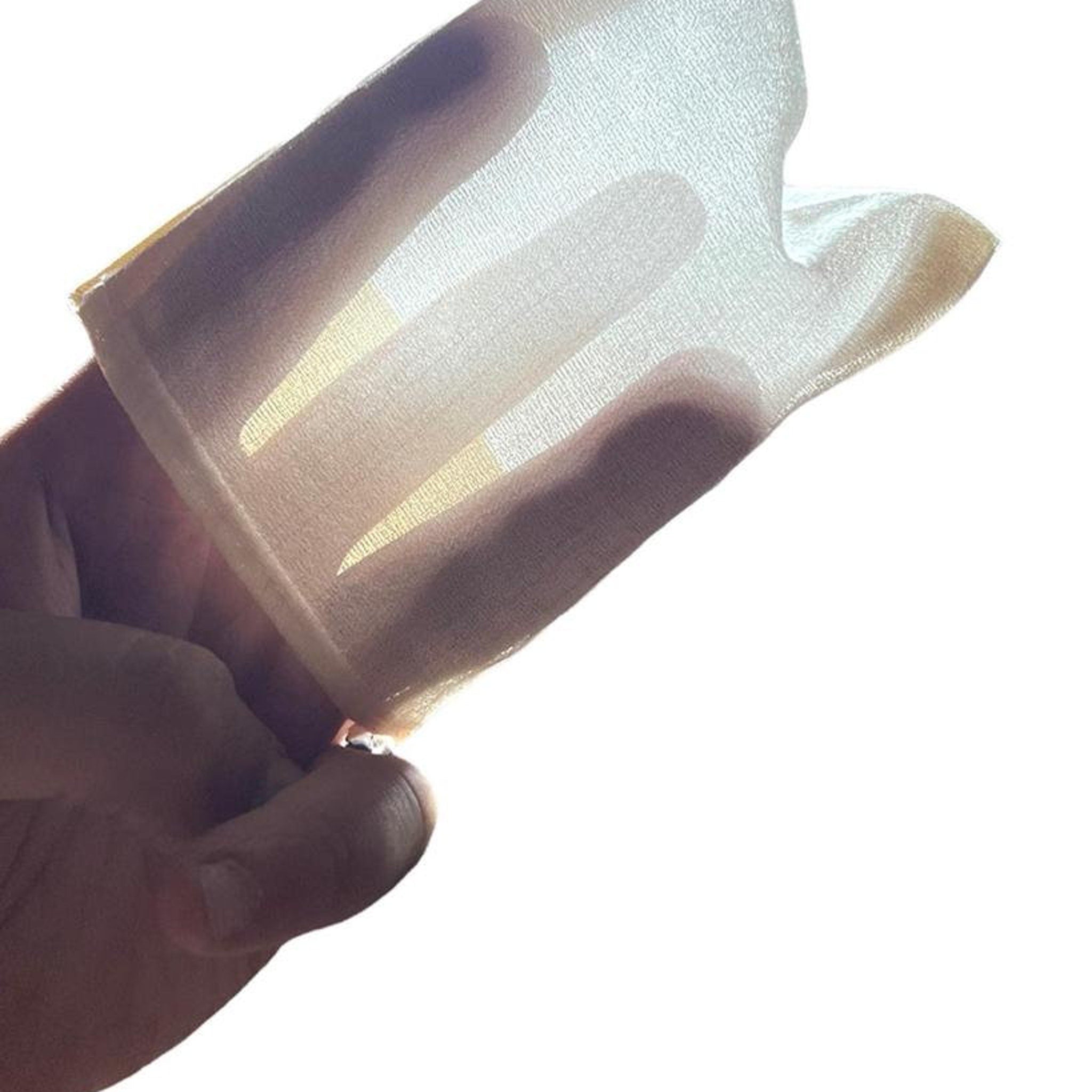 Sheer fabric, cream color, held in hand, showing texture and light