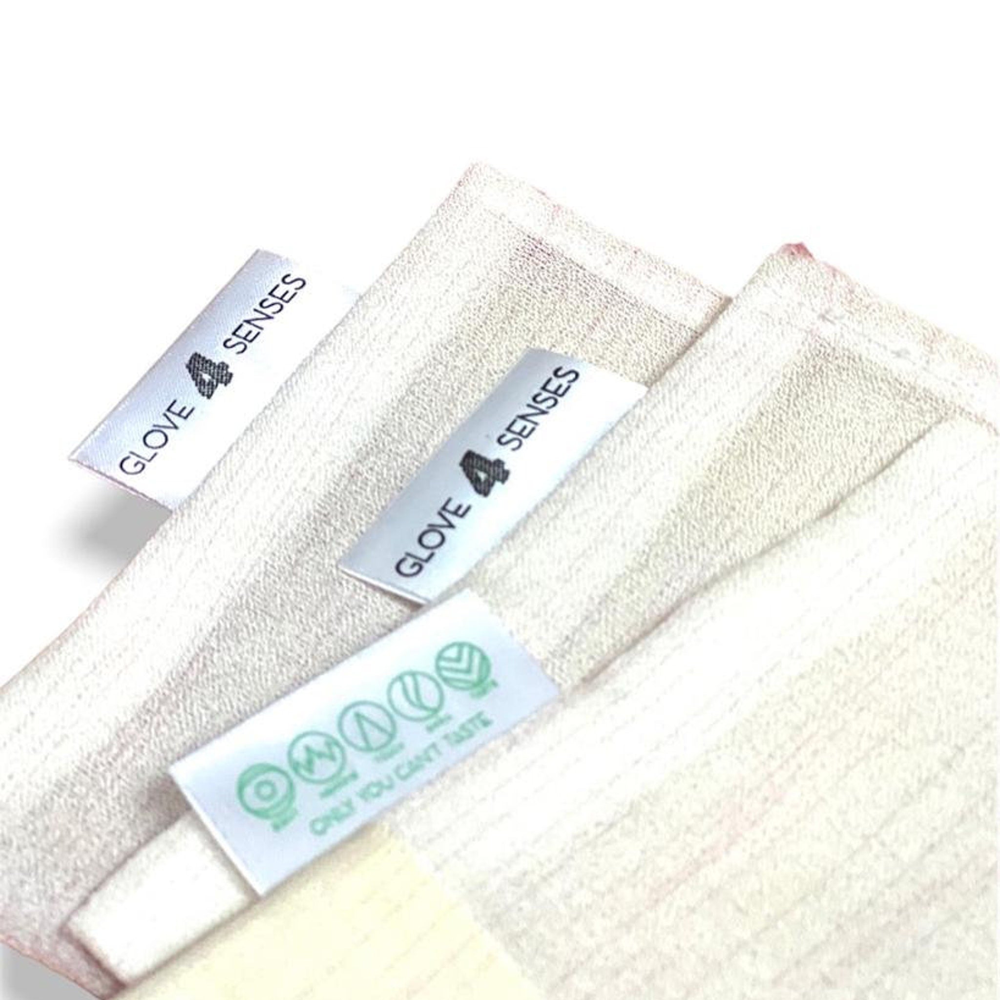 Cloth squares with textured material, off-white color, and "GLOVE 4 SENSES" labels