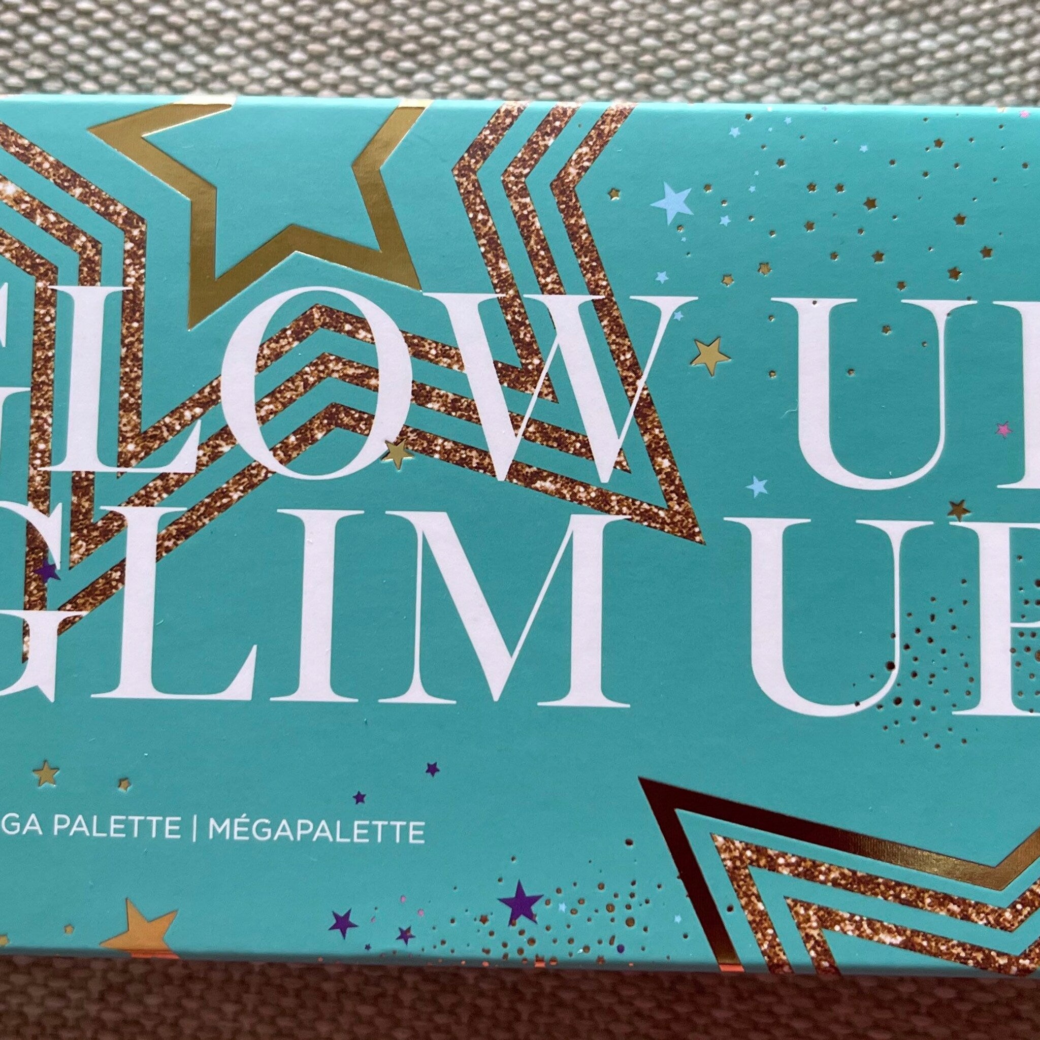 Side view of Avon Glimmer Glow Up palette showing sleek black compact with gold trim and embossed logo