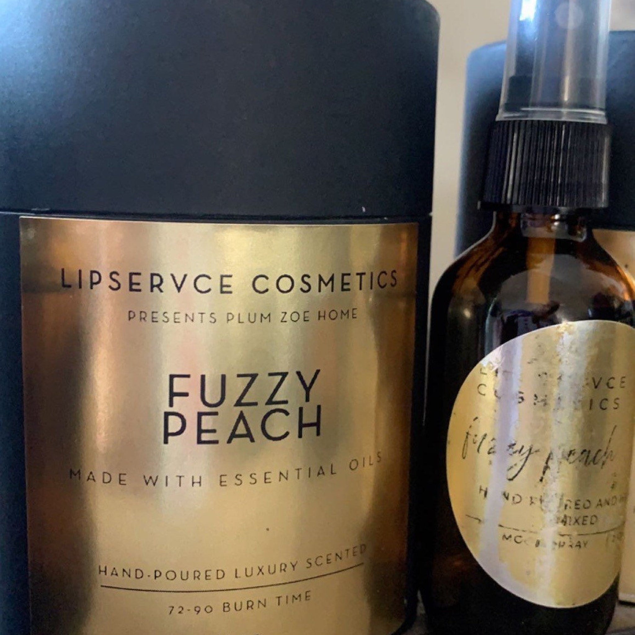 Scented candle and spray set with gold label, black bottle, and "Fuzzy Peach" text by Lipservce Cosmetics