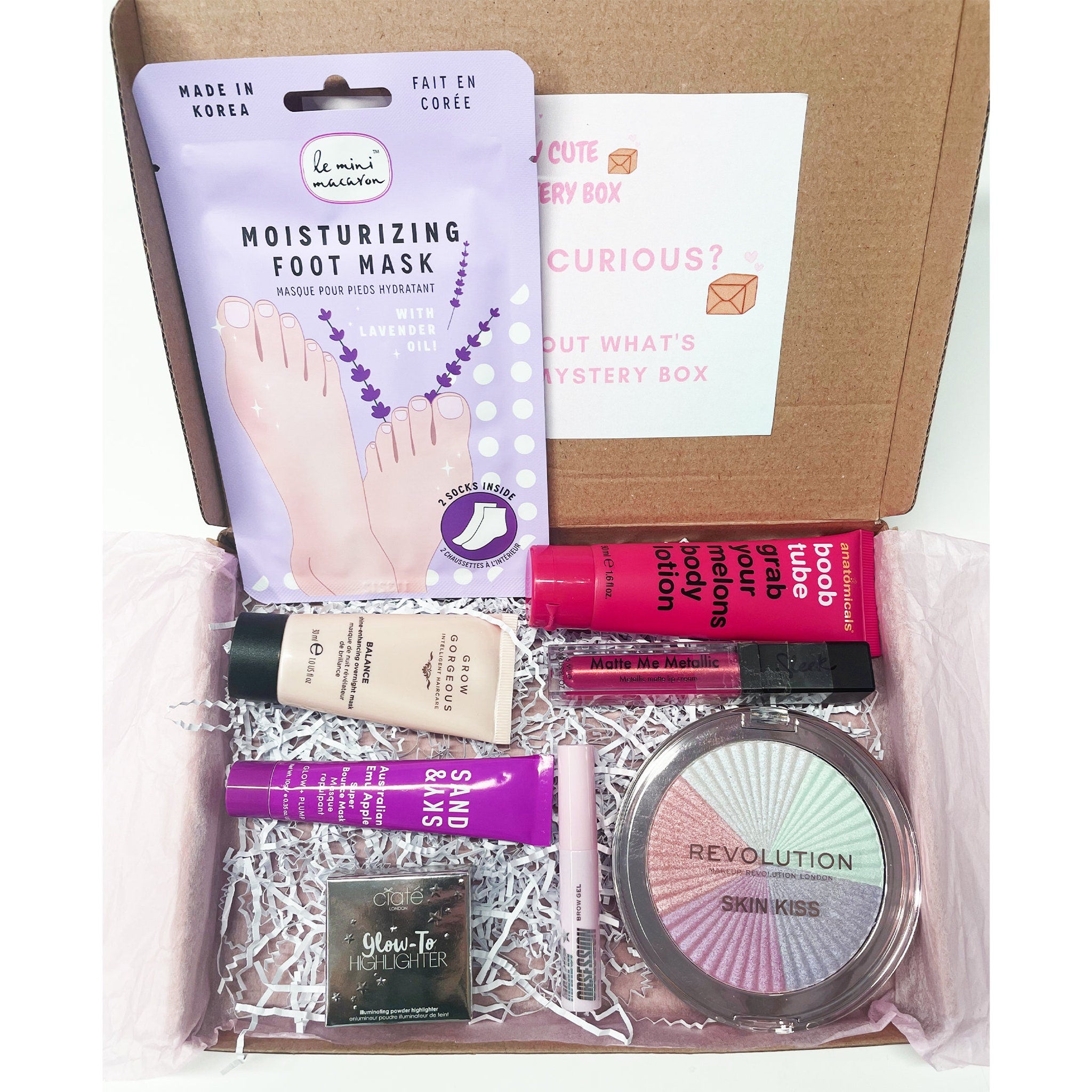 Gift box with pink satin bow and heart-shaped eye shadow palette nestled in tissue paper