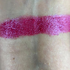Side view of Tickle Eye Shadow compact showing shimmering peach powder and sleek black case design
