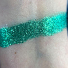 Close-up of zodiac-inspired eye shadow palette showing shimmering celestial blue and deep cosmic purple shades