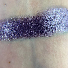Close-up of artist applying shimmery bronze eye shadow with a fluffy brush onto eyelid