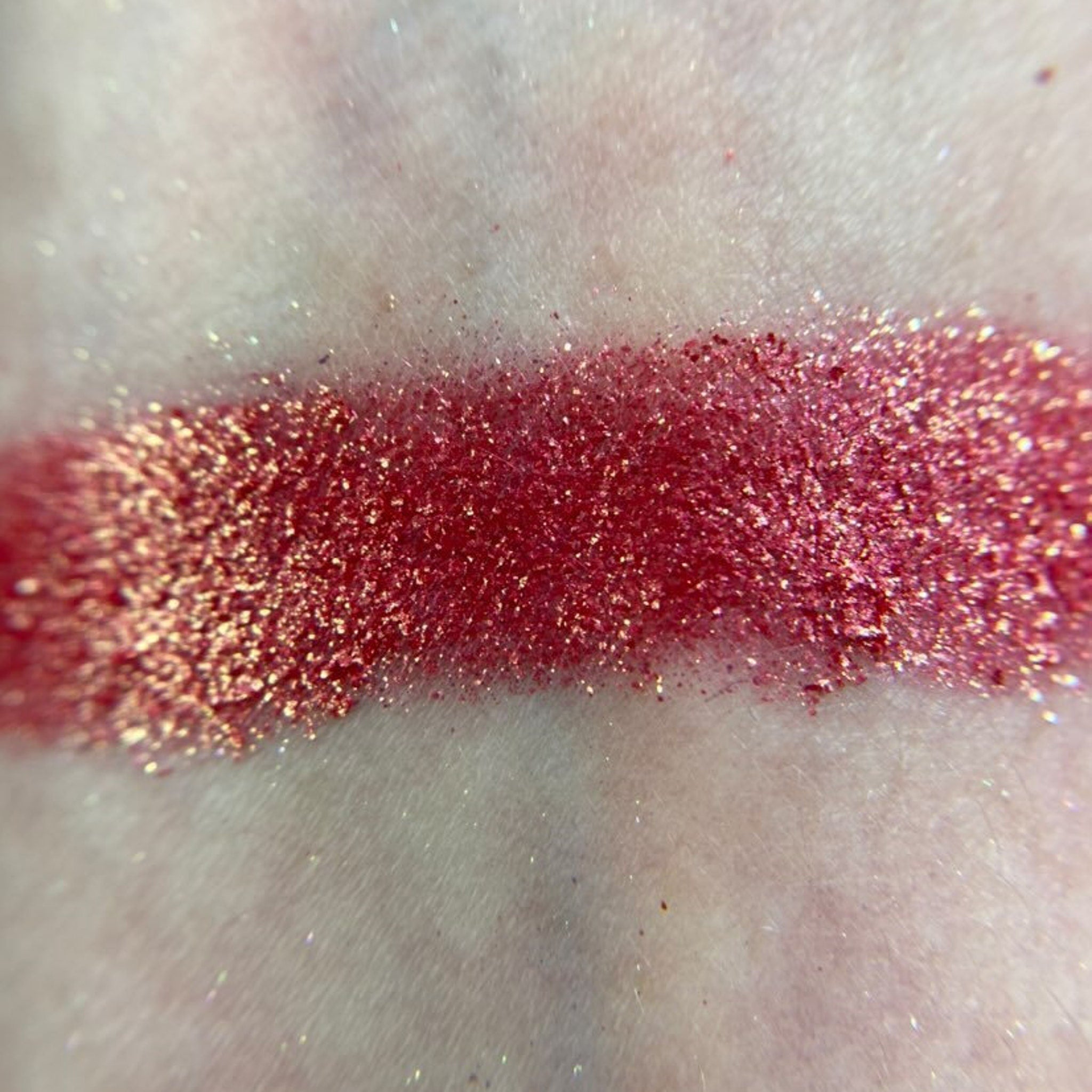 Close-up of a hand applying shimmery taupe eyeshadow from the M80 palette with a fluffy brush