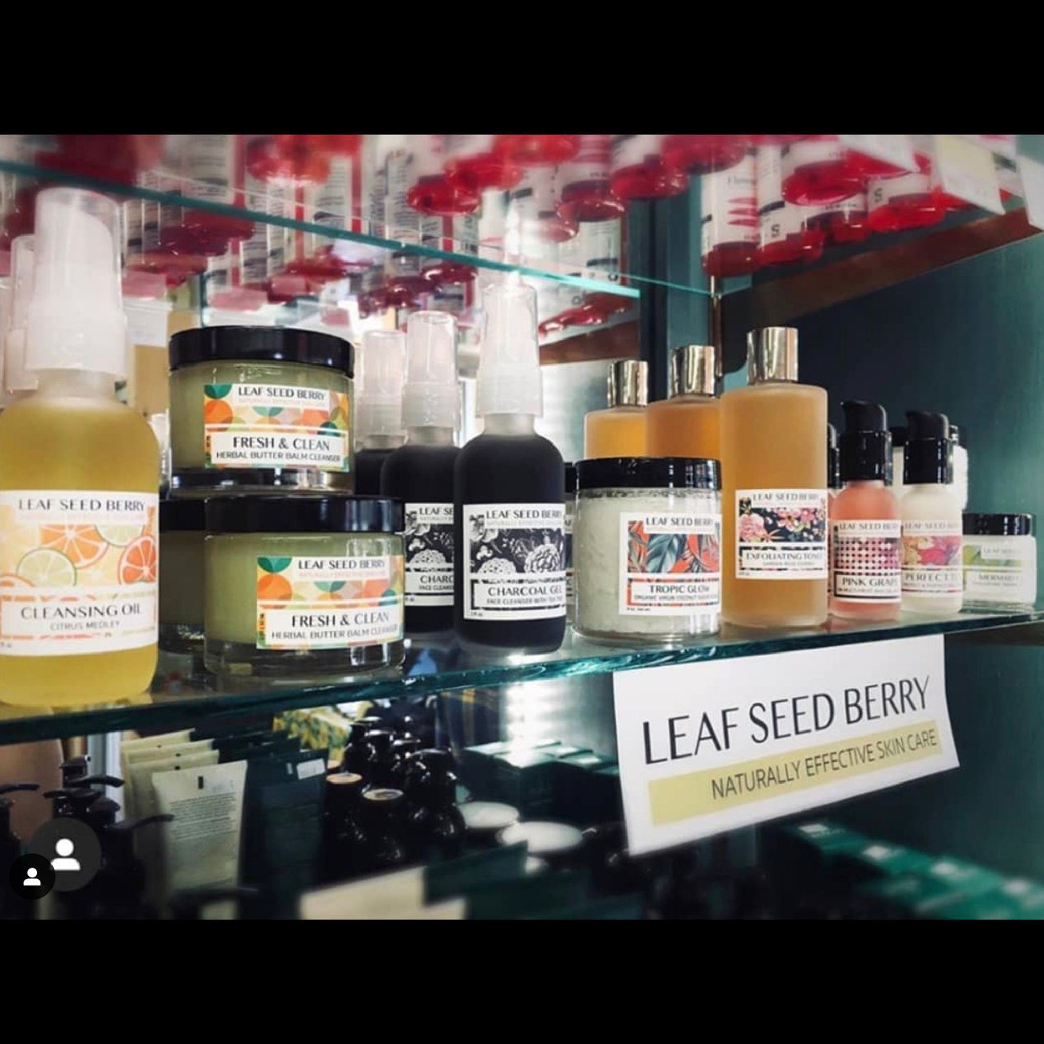 Skincare products in glass bottles and jars, with Leaf Seed Berry branding, displayed on shelves