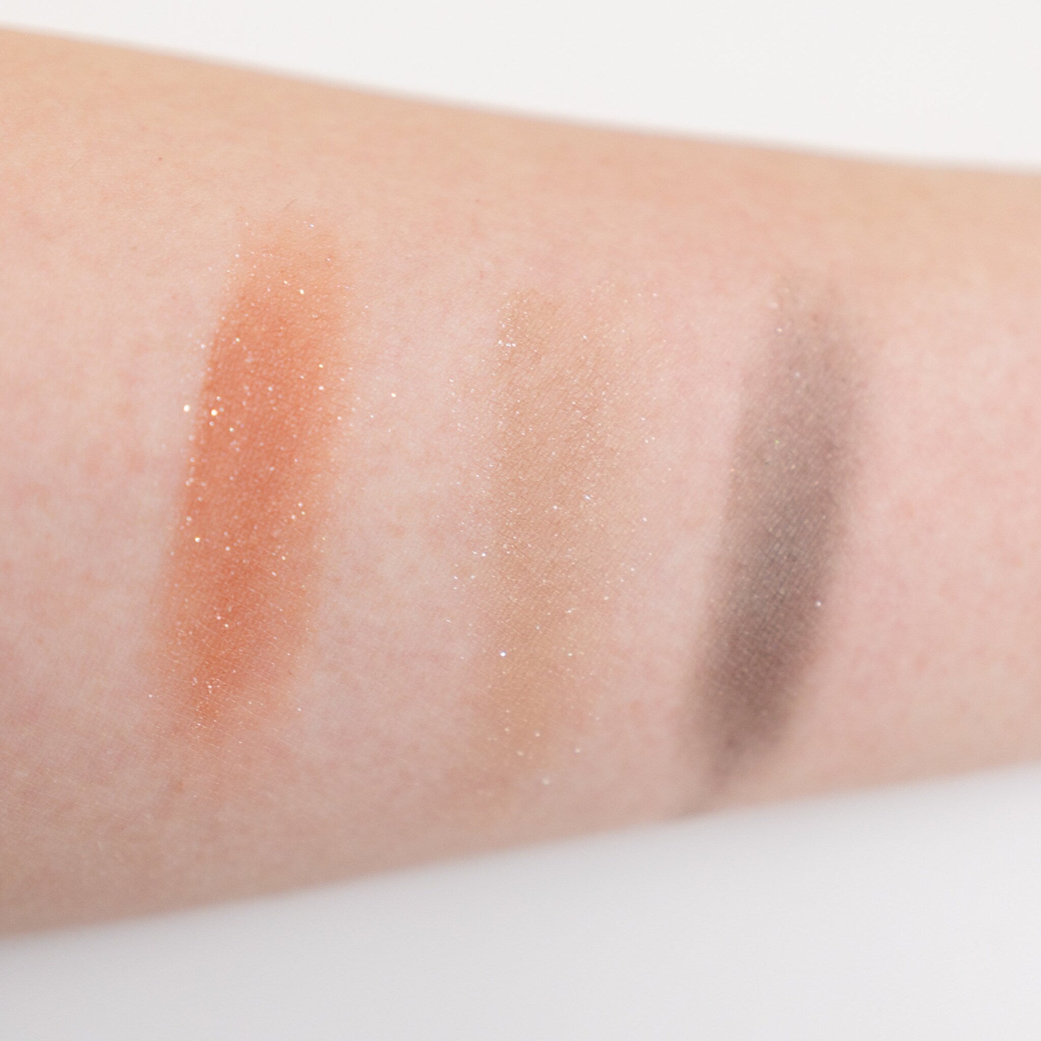 Sunset Peach eyeshadow pan with sheer orange sequin shimmer on a clean white surface