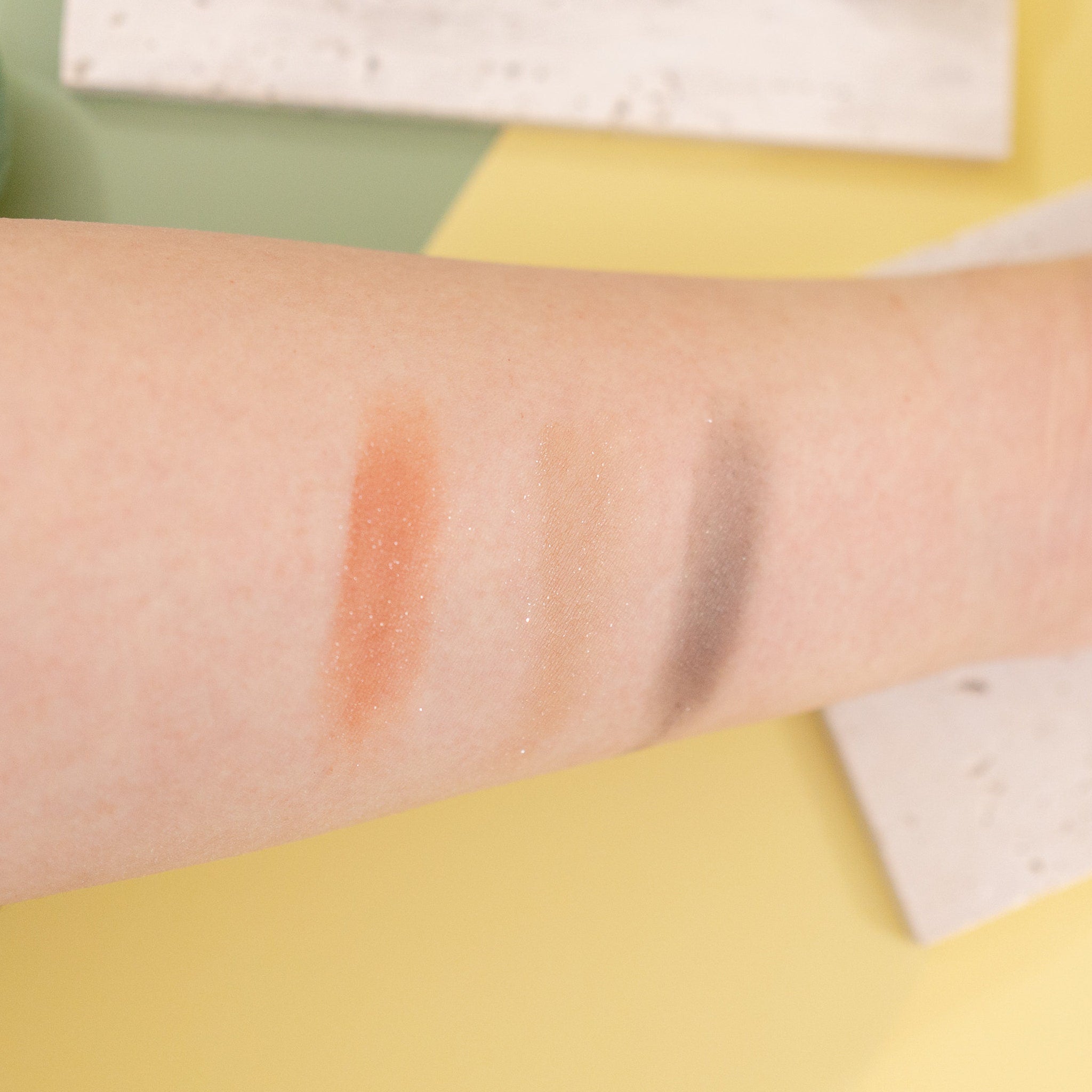 Sunset Peach eyeshadow pan with sheer orange sequin shimmer catching light at an angle