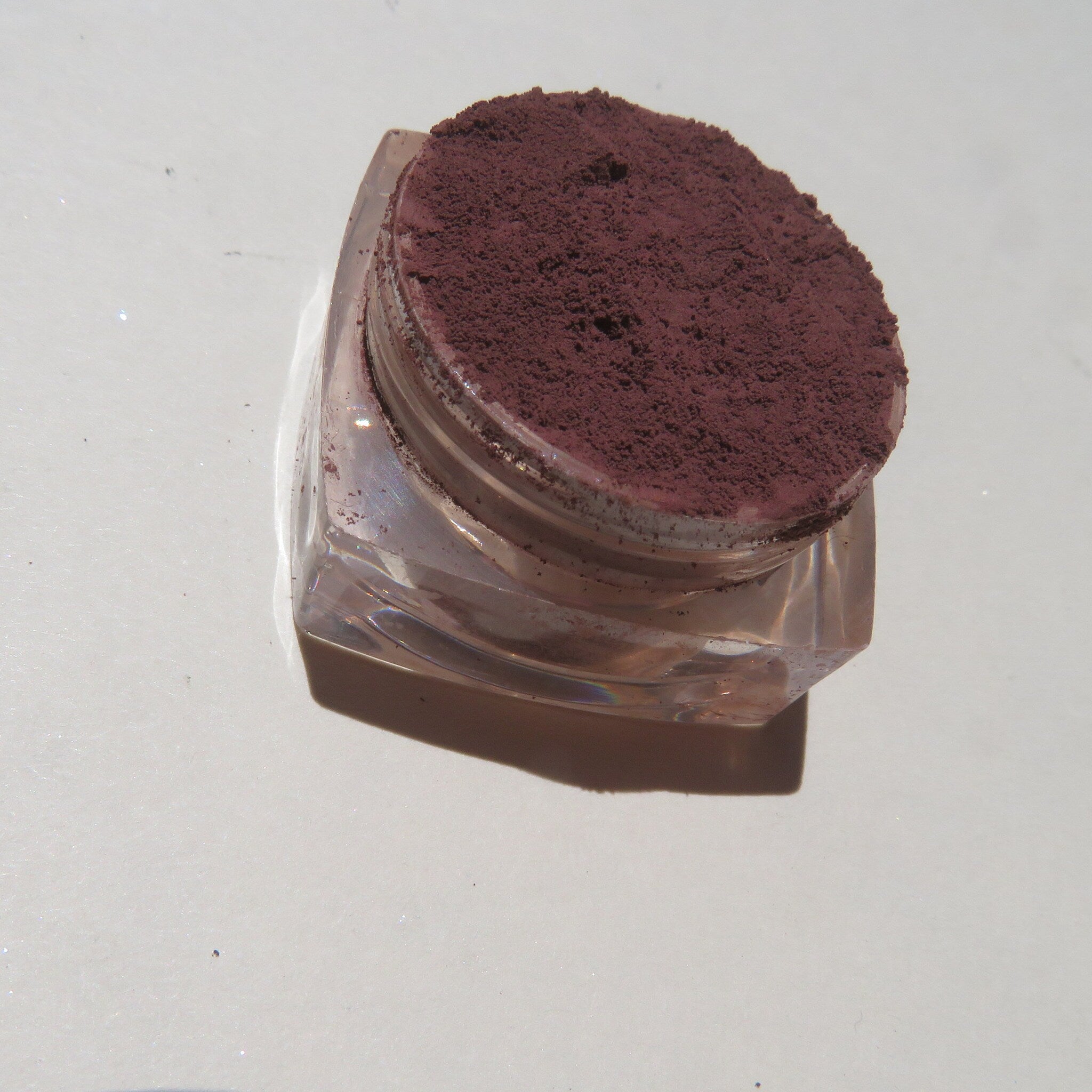 Open compact showing matte dark brown purple mineral eyeshadow with vegan cruelty-free label