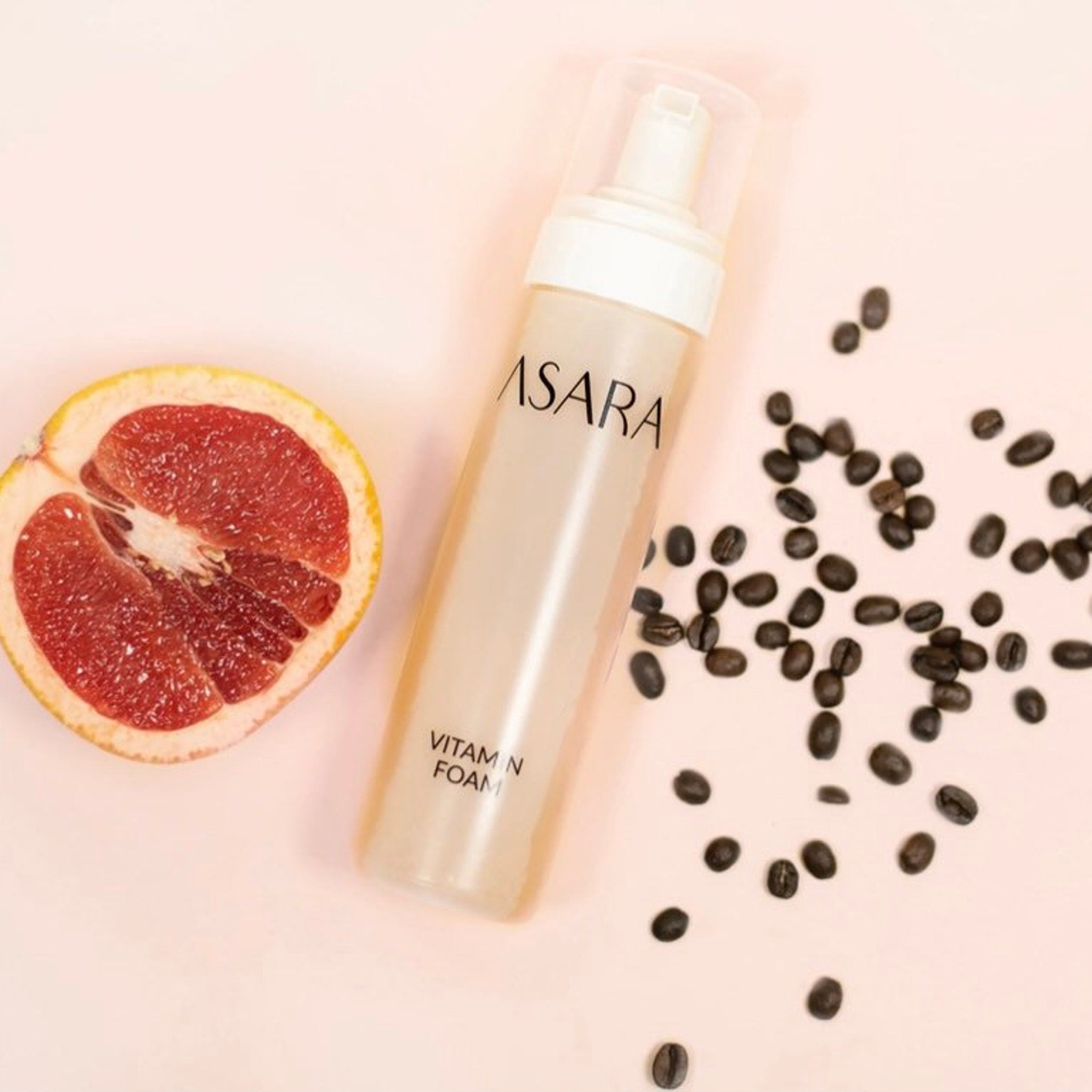 Vitamin foam bottle with white pump, ASARA text, and coffee beans on pink background