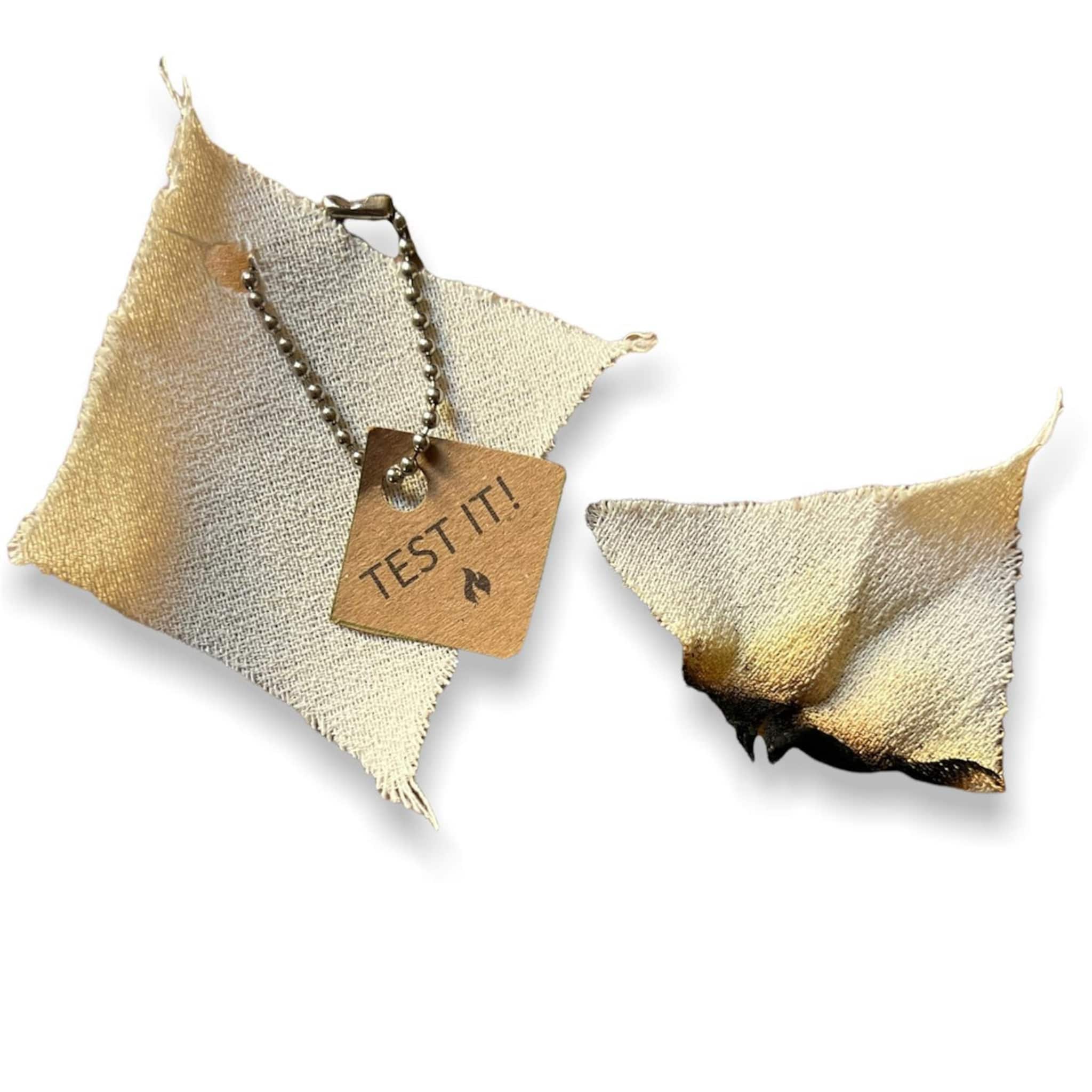 Fabric swatch with tan and burnt edges, "TEST IT!" tag, and chain detail