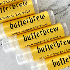 Lip balm tubes with yellow labels, black text, and clear plastic packaging, CozySloth Butterbrew