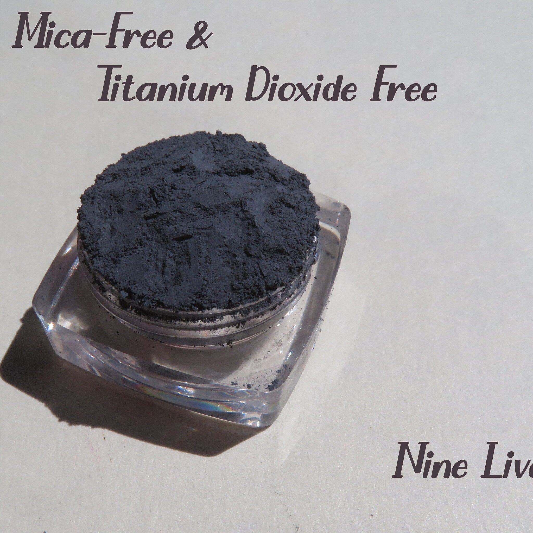 Dark gray matte loose mineral eyeshadow in a round black jar with silver lid, vegan and cruelty-free makeup pigment